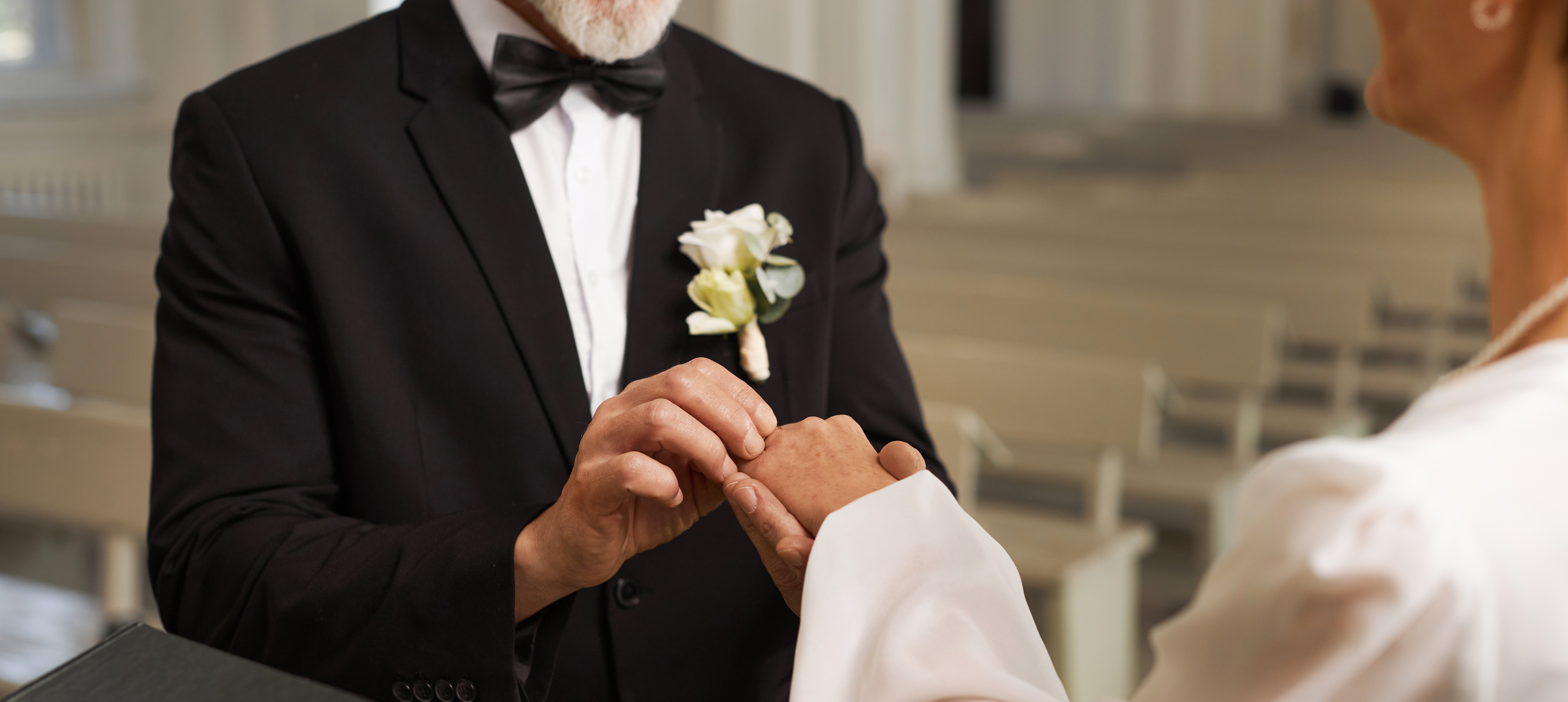 Close up of senior couple exchanging wedding rings