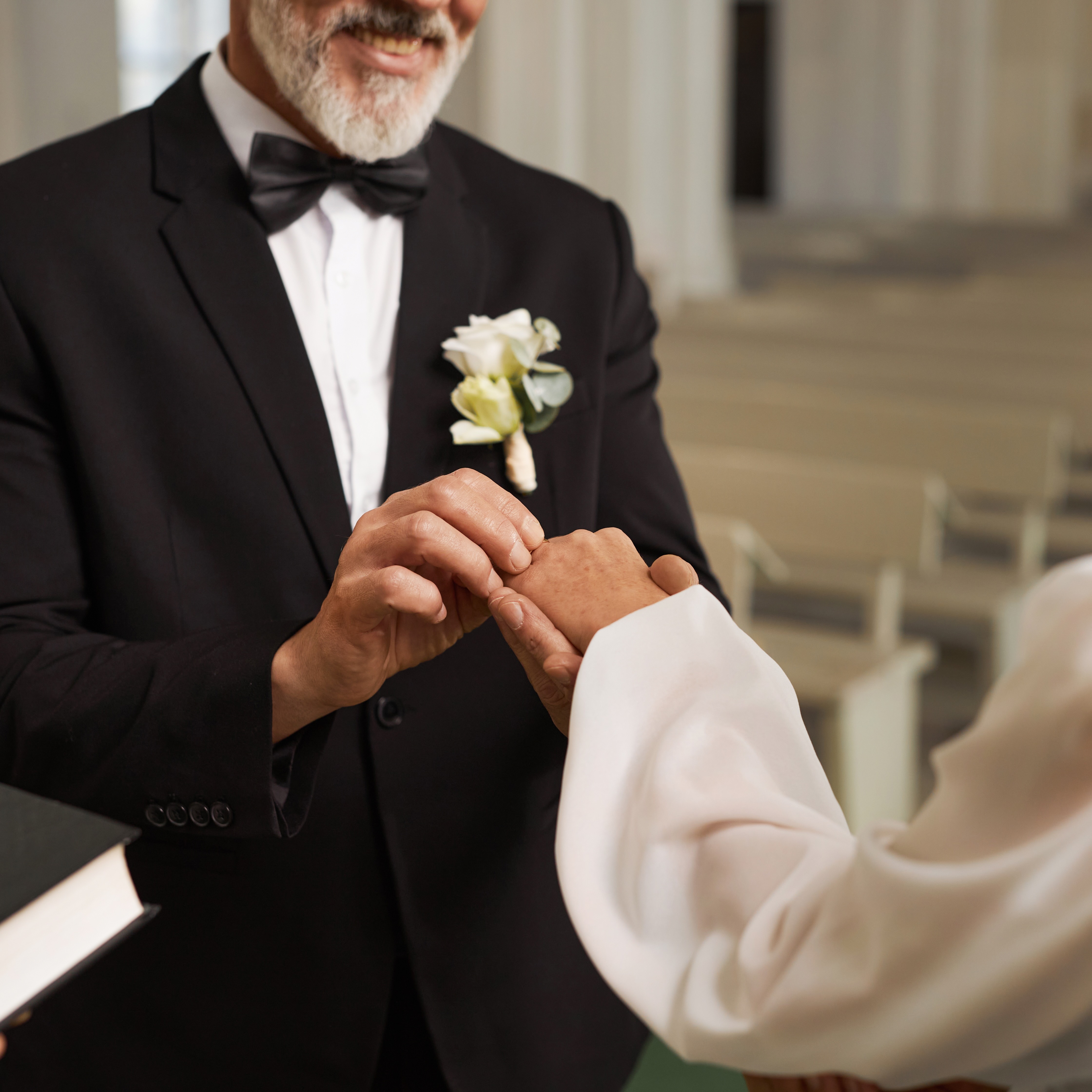 Close up of senior couple exchanging wedding rings