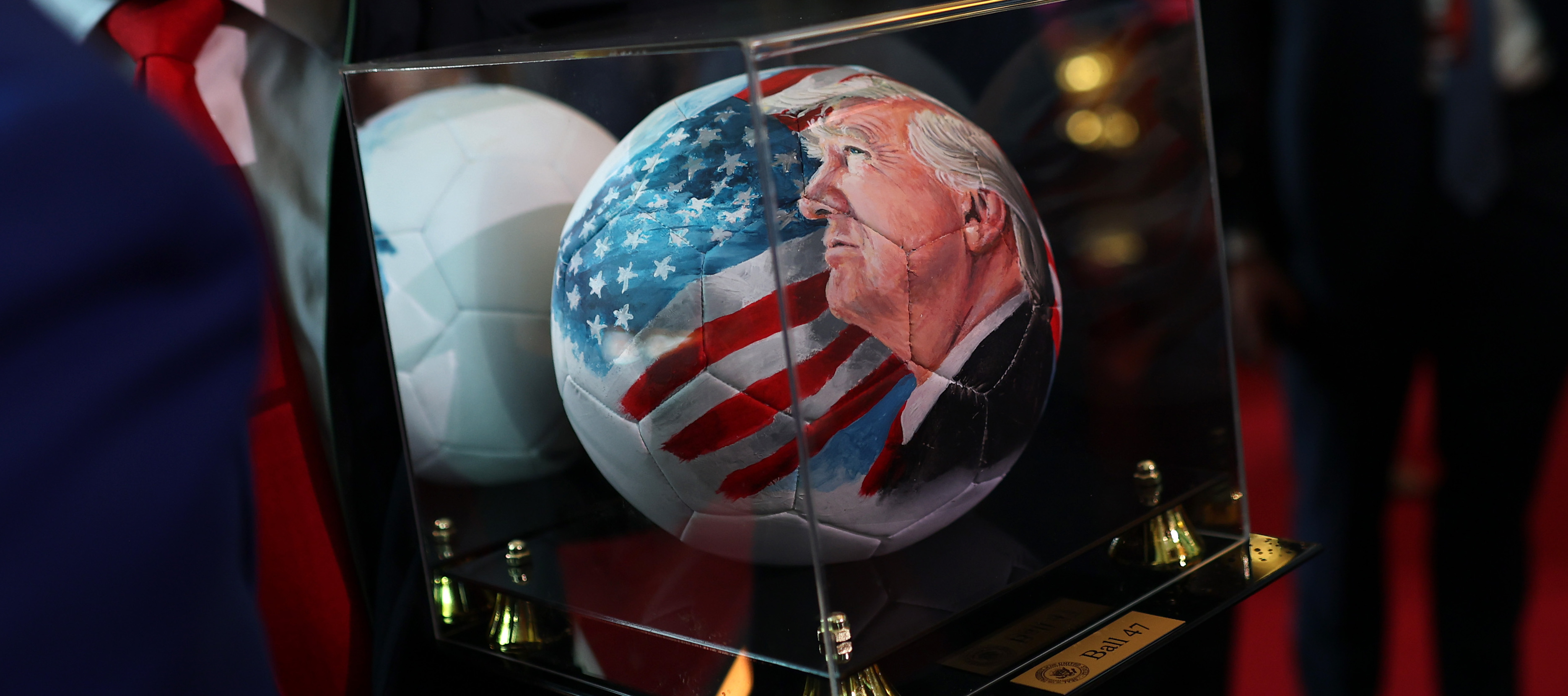 A close up of a soccer ball imprinted with an image of President's Trump's face upon it.