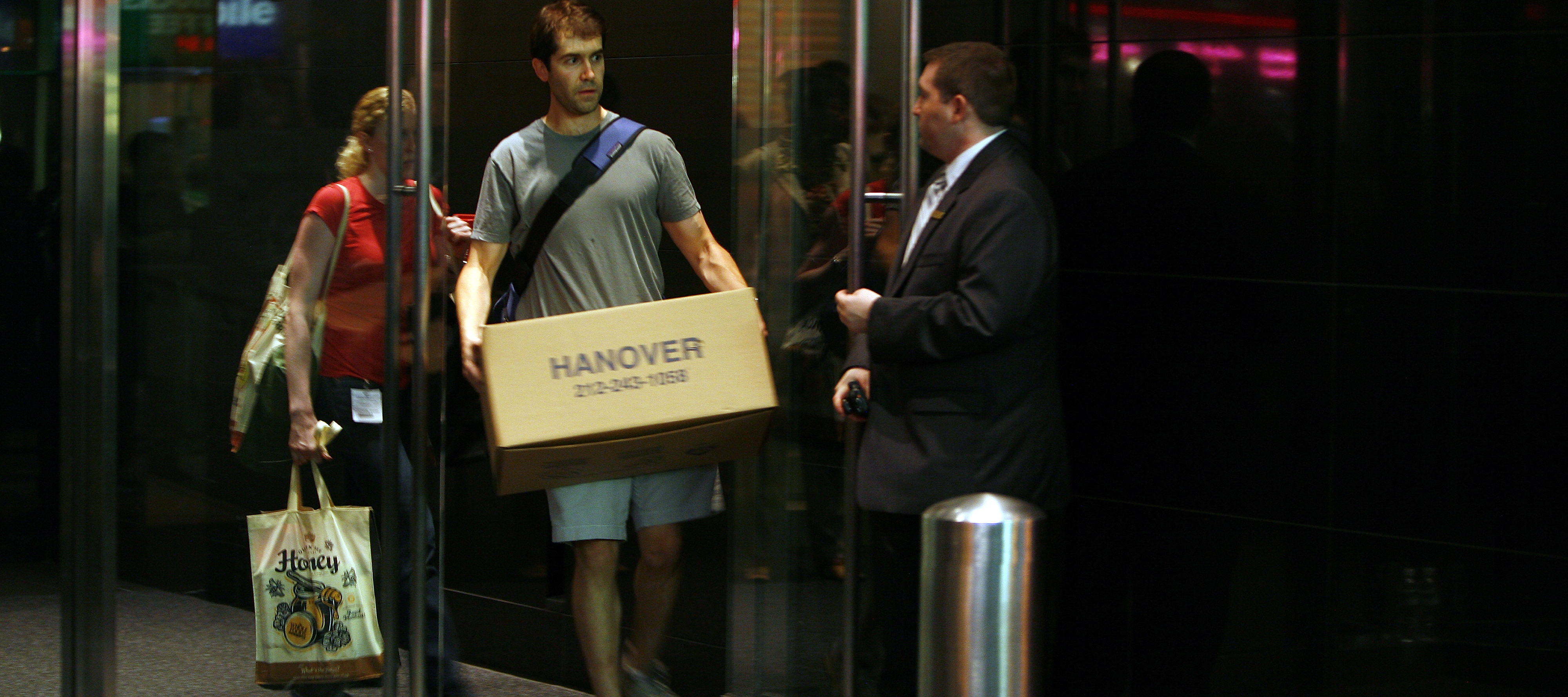 An employee leaves the investment banking house Lehman Brothers, while carrying his private belonging in a box.