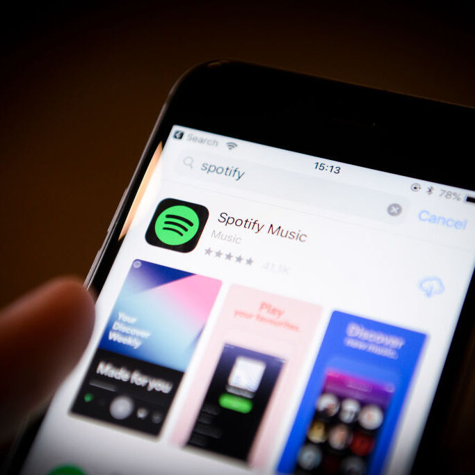 A photo of a smartphone with the Spotify app showing in the App Store