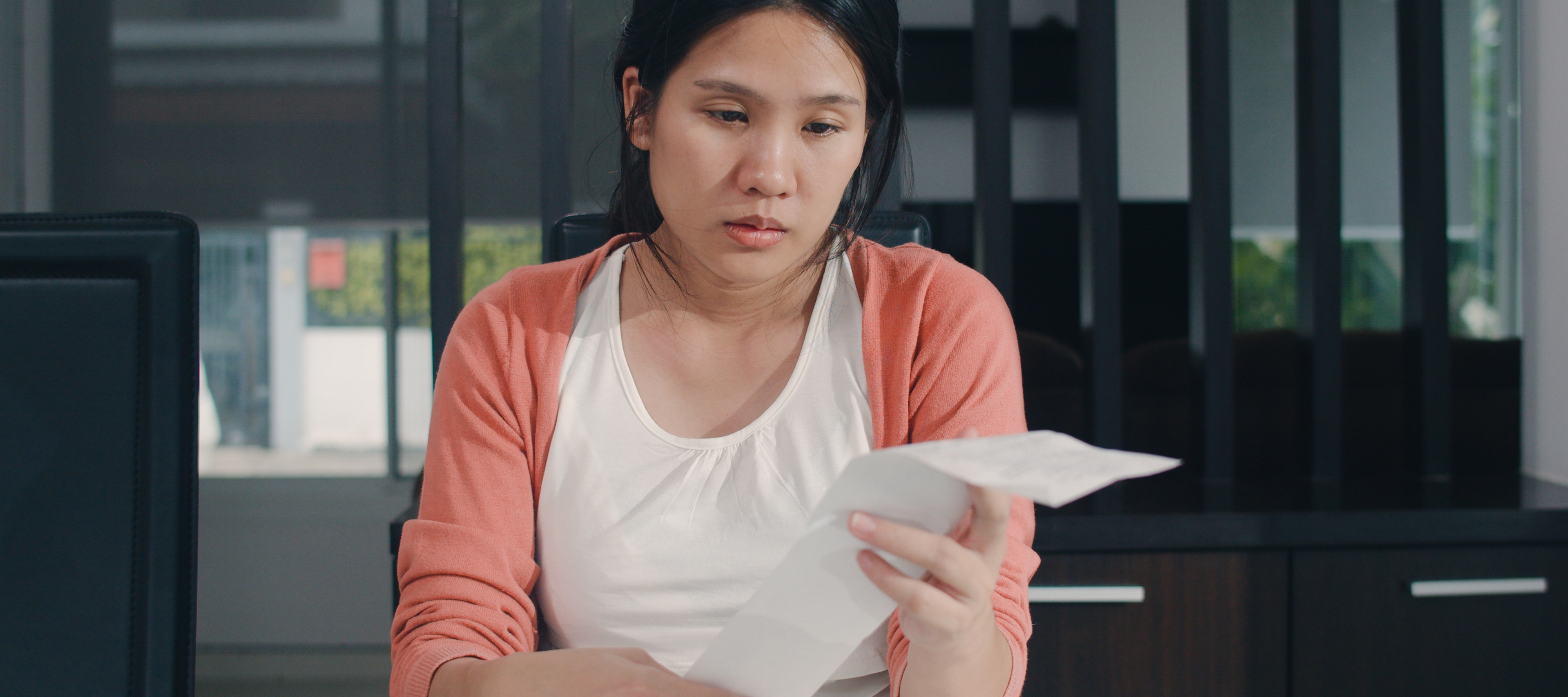 Young woman looking disappointed by long receipt