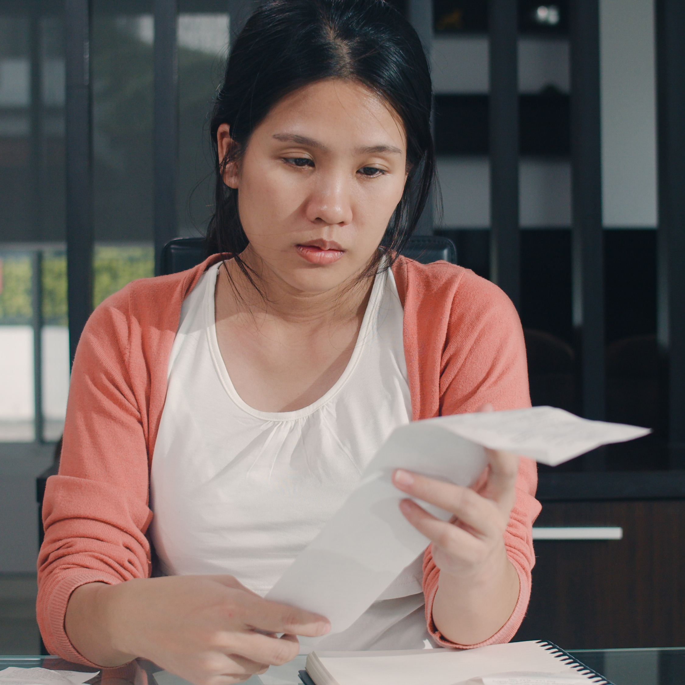 Young woman looking disappointed by long receipt