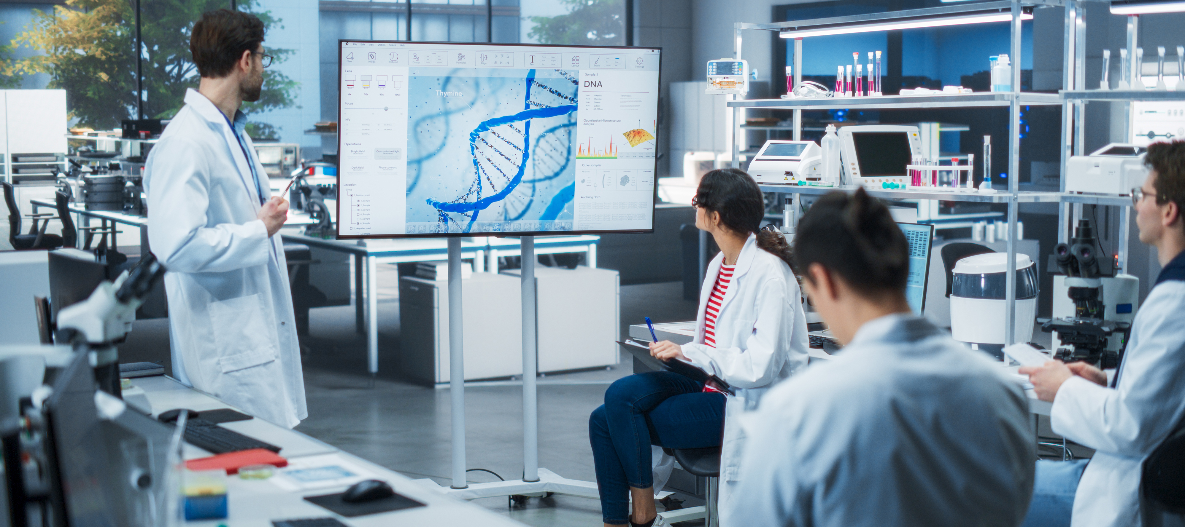 A group of scientists gather to discuss trends in gene therapy in a lab.