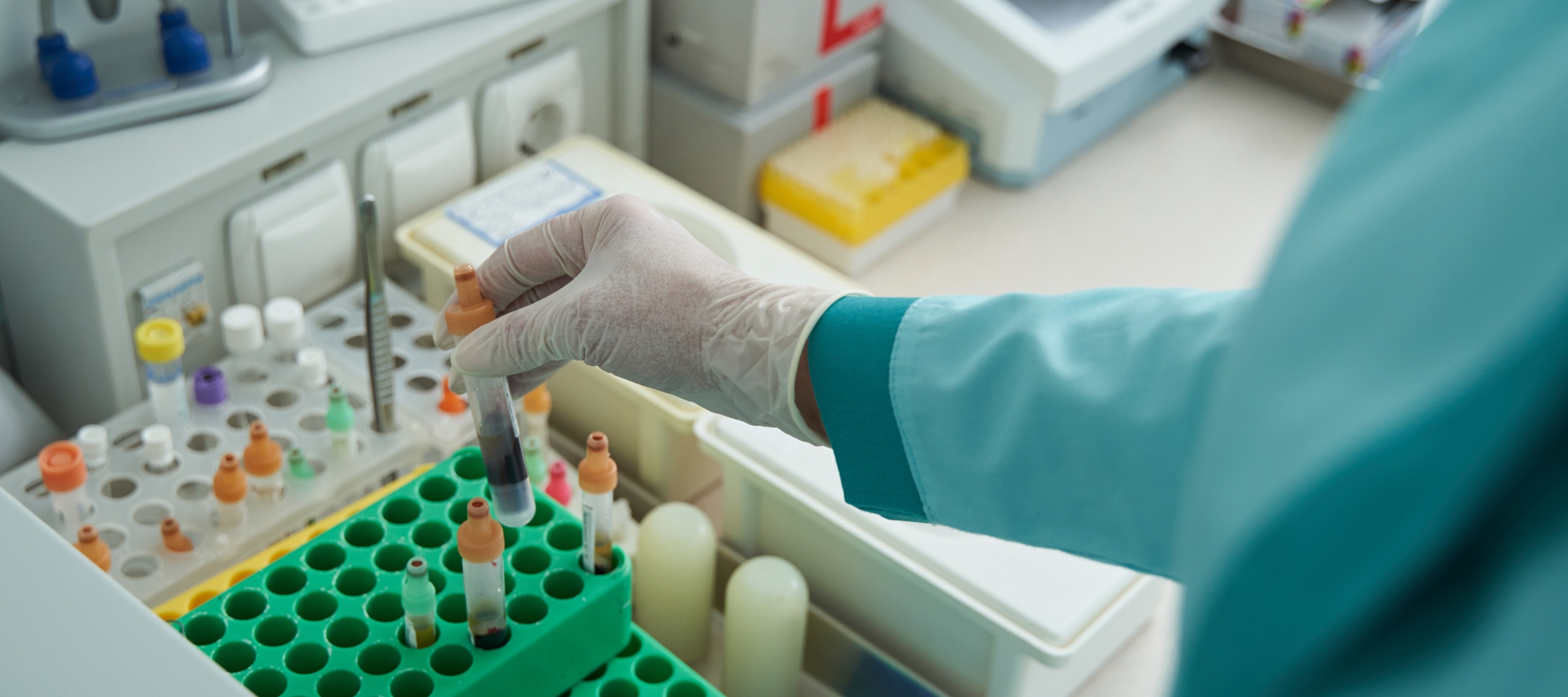 A lab technician sorts through a rack of vials.
