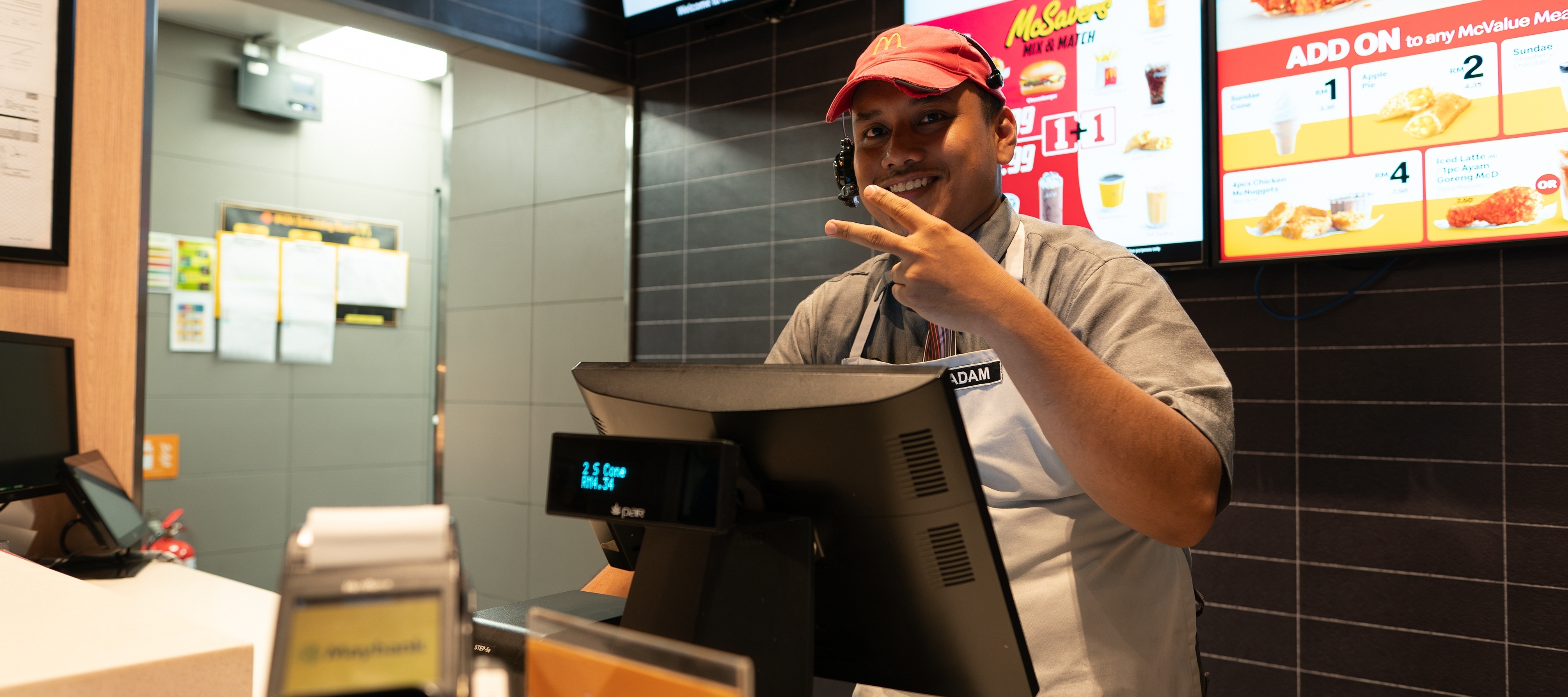 A McDonald's worker gives the victory sign with his hands.