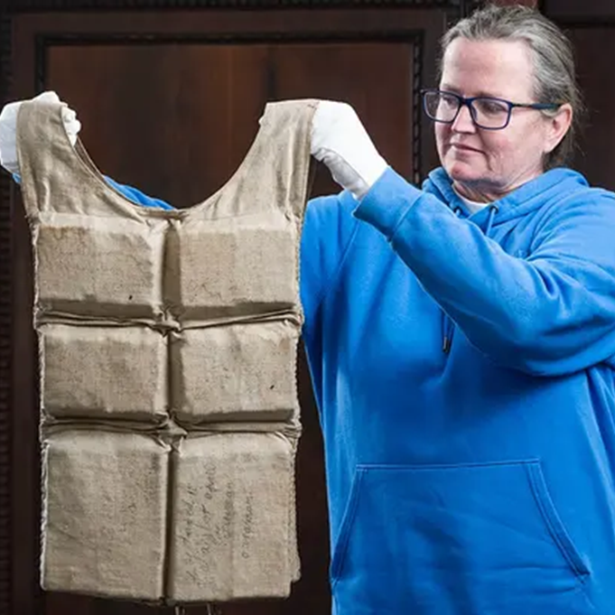 A member of the Henry Aldridge and Son staff holds up the Titanic life jacket that was auctioned off.