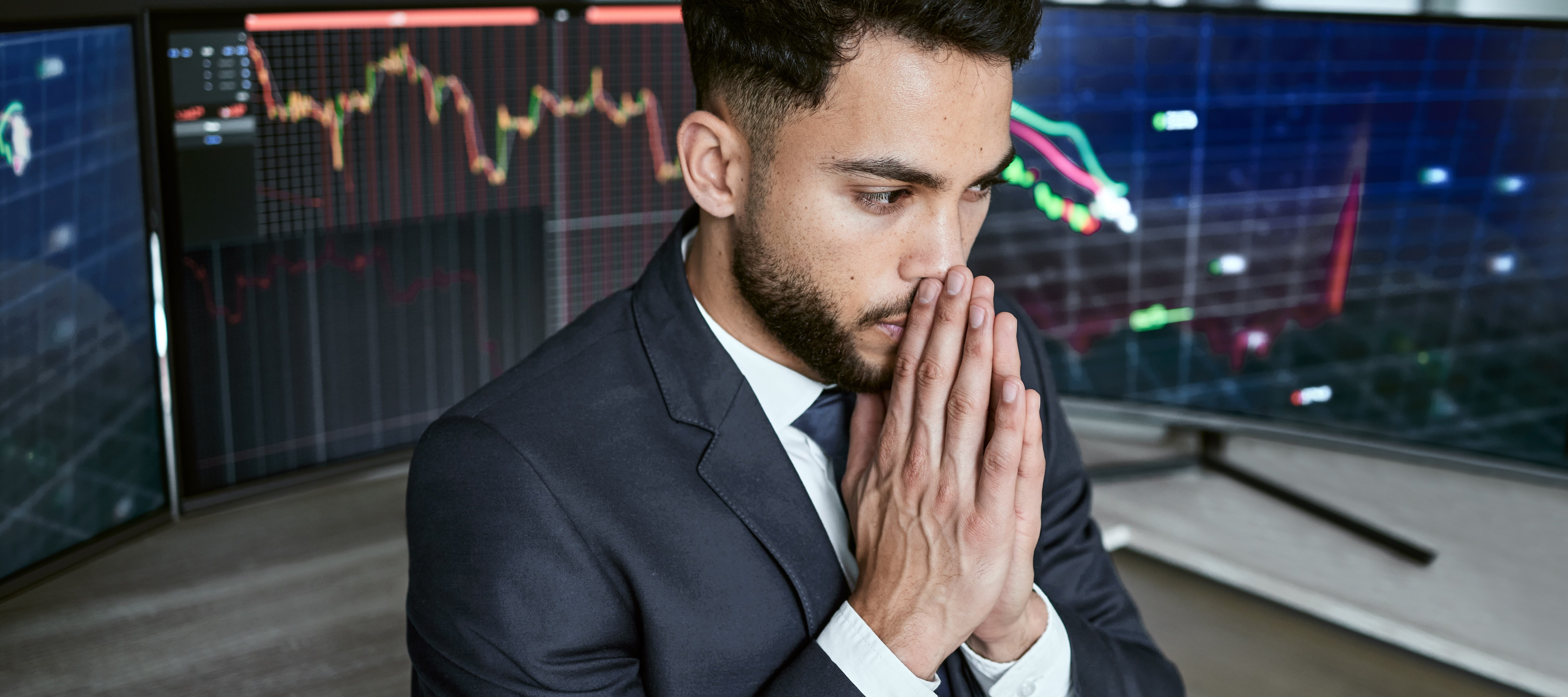 Young man looking stressed while monitoring stocks