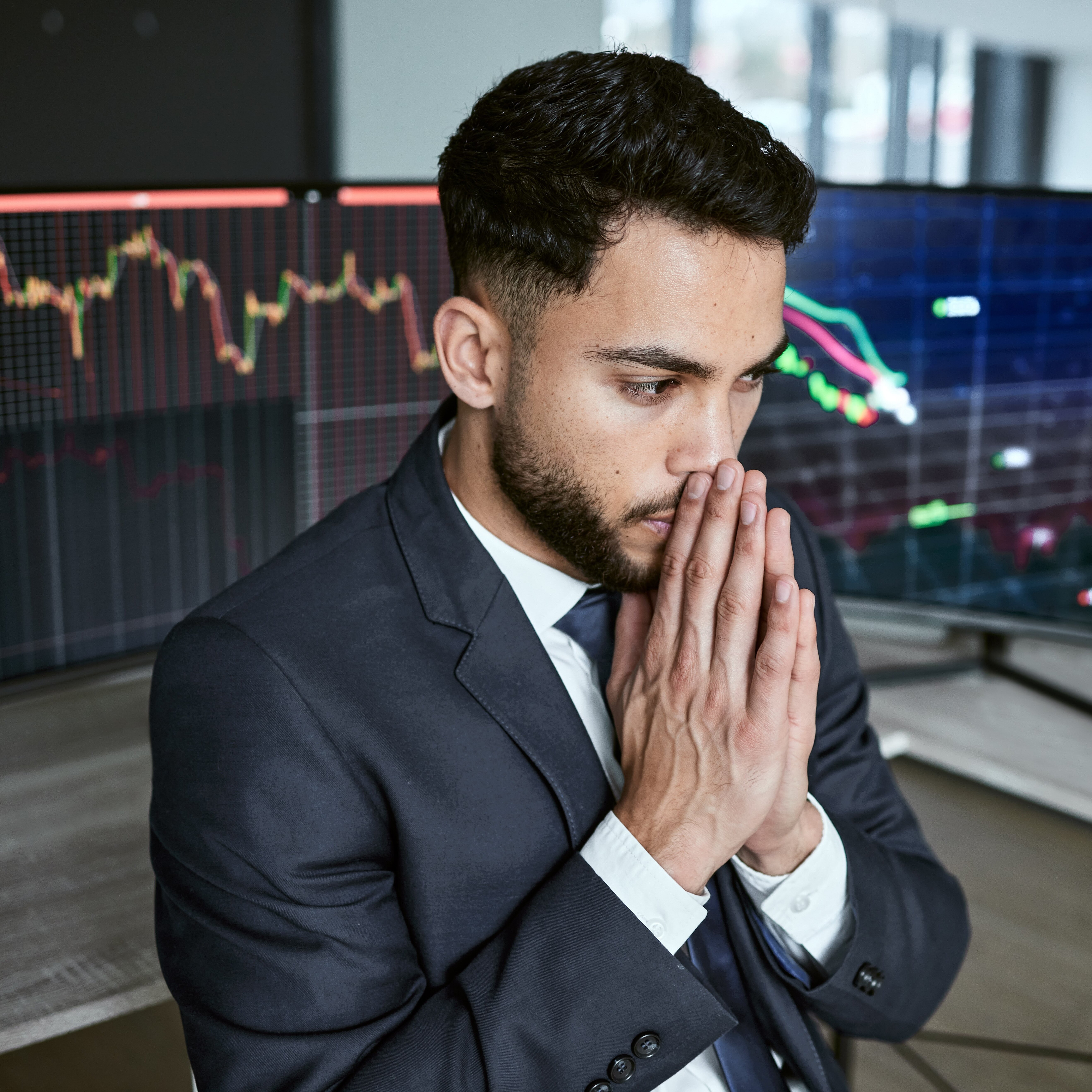 Young man looking stressed while monitoring stocks