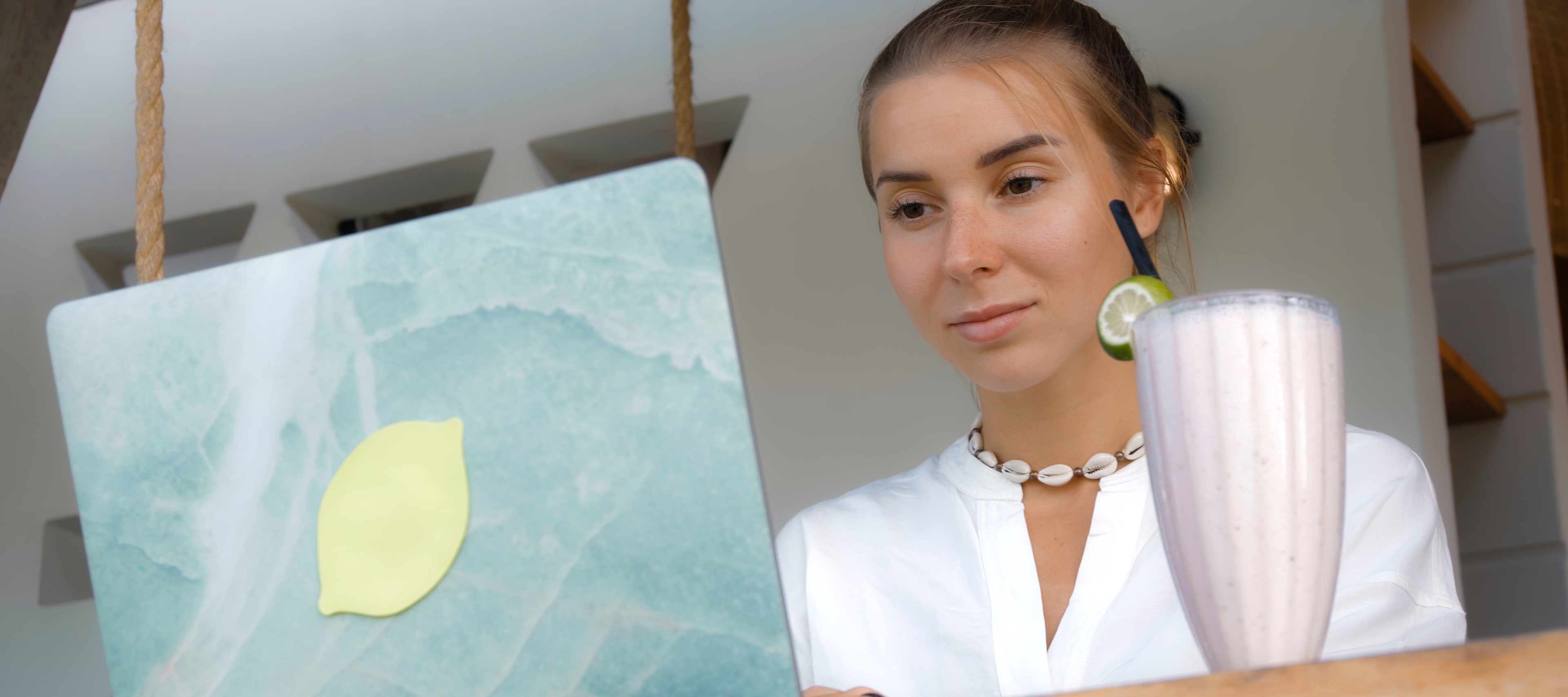 Young woman with a sly smile working on her laptop.