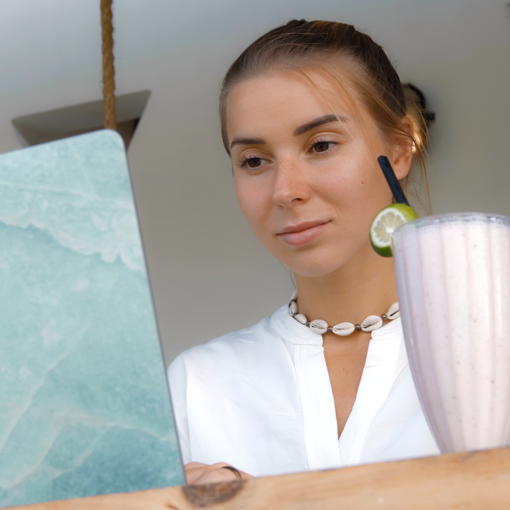Young woman with a sly smile working on her laptop.