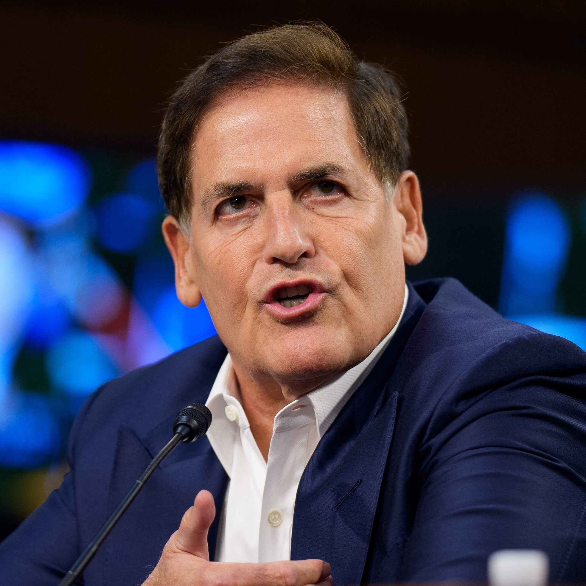 Mark Cuban speaks during a Senate Committee seated before a microphone.