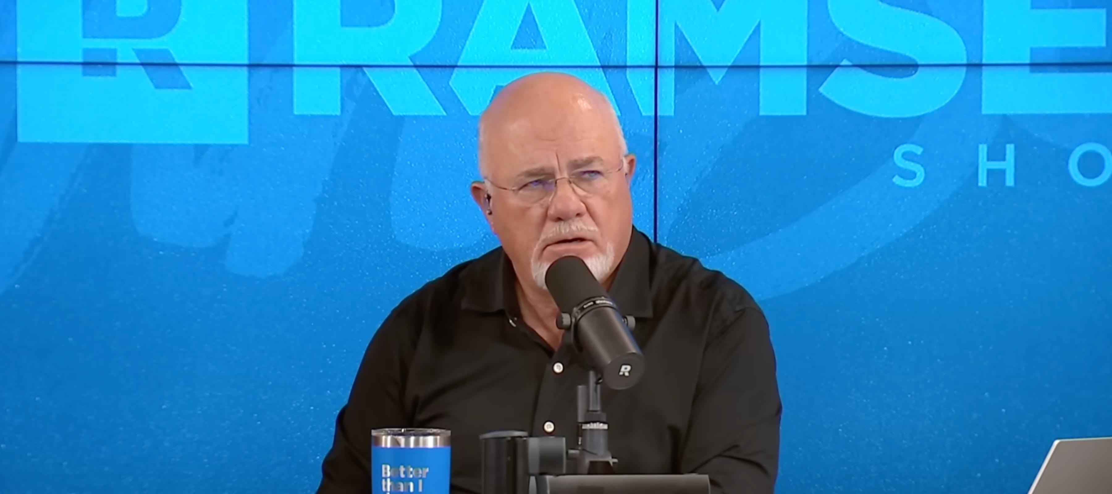 Dave Ramsey seen on set of his radio show, looking aghast as caller explains her situation.
