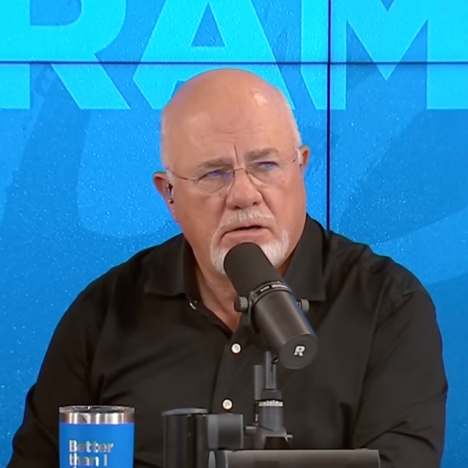 Dave Ramsey seen on set of his radio show, looking aghast as caller explains her situation.