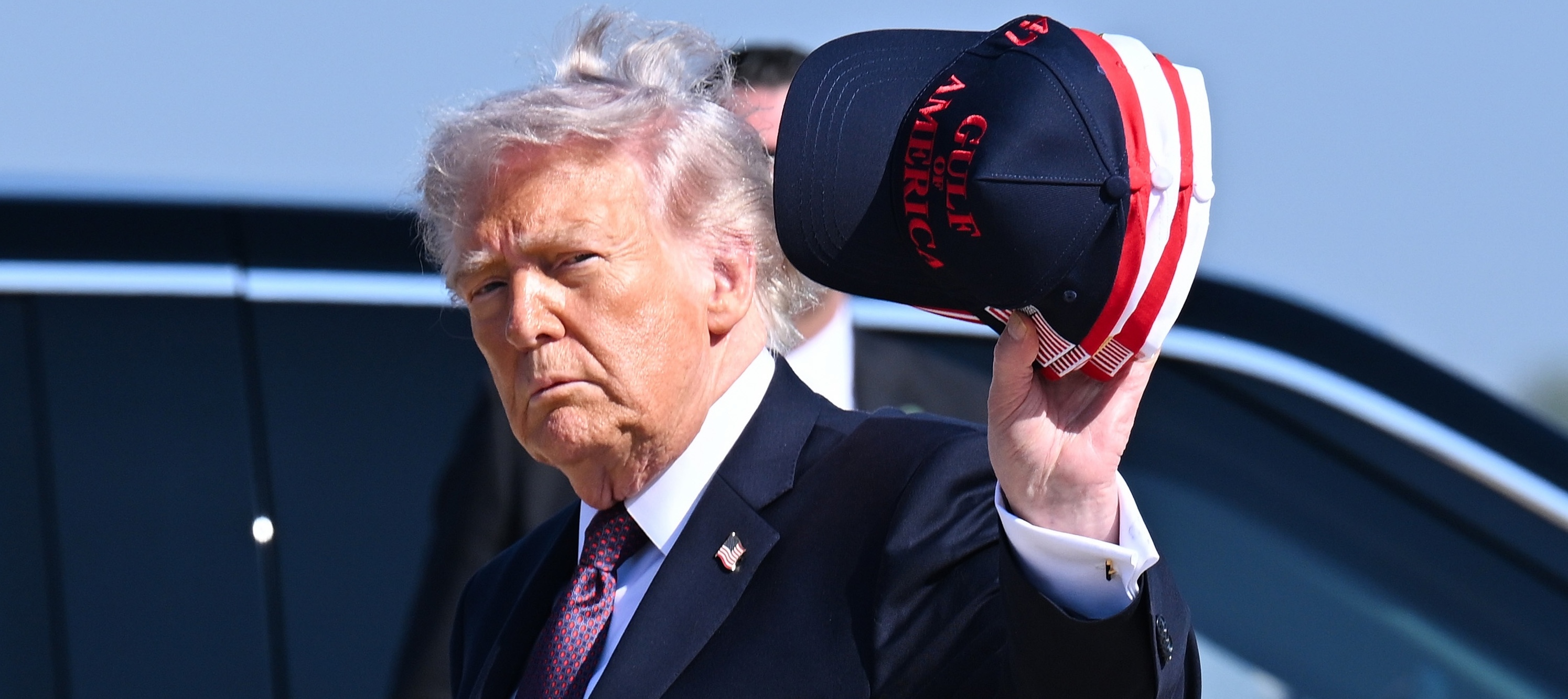 President Trump waves with a Gulf of America cap.