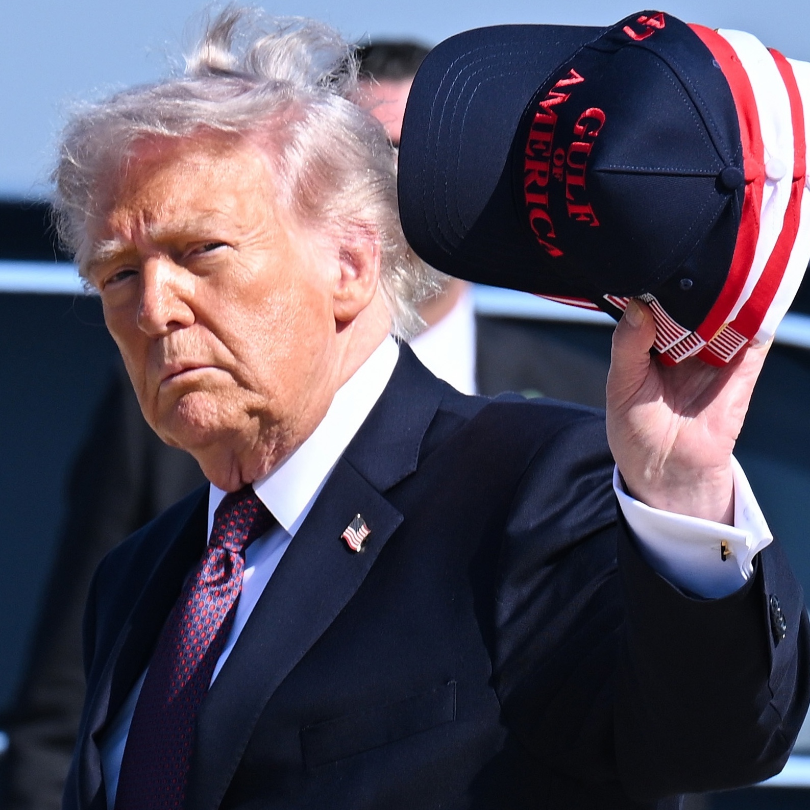 President Trump waves with a Gulf of America cap.