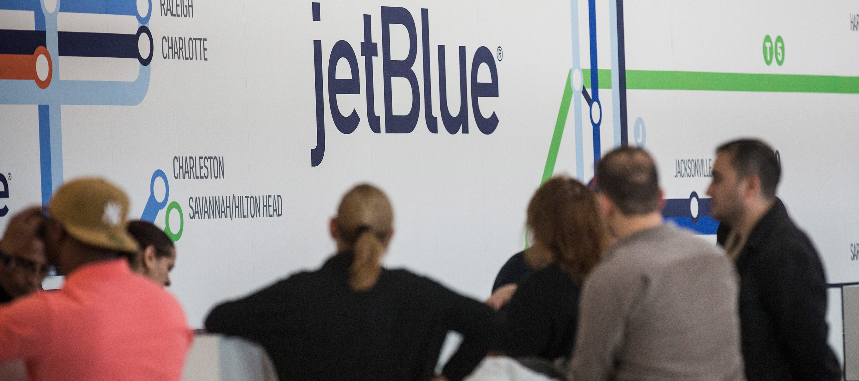 Customers gather around a JetBlue counter at John F. Kennedy Airport.