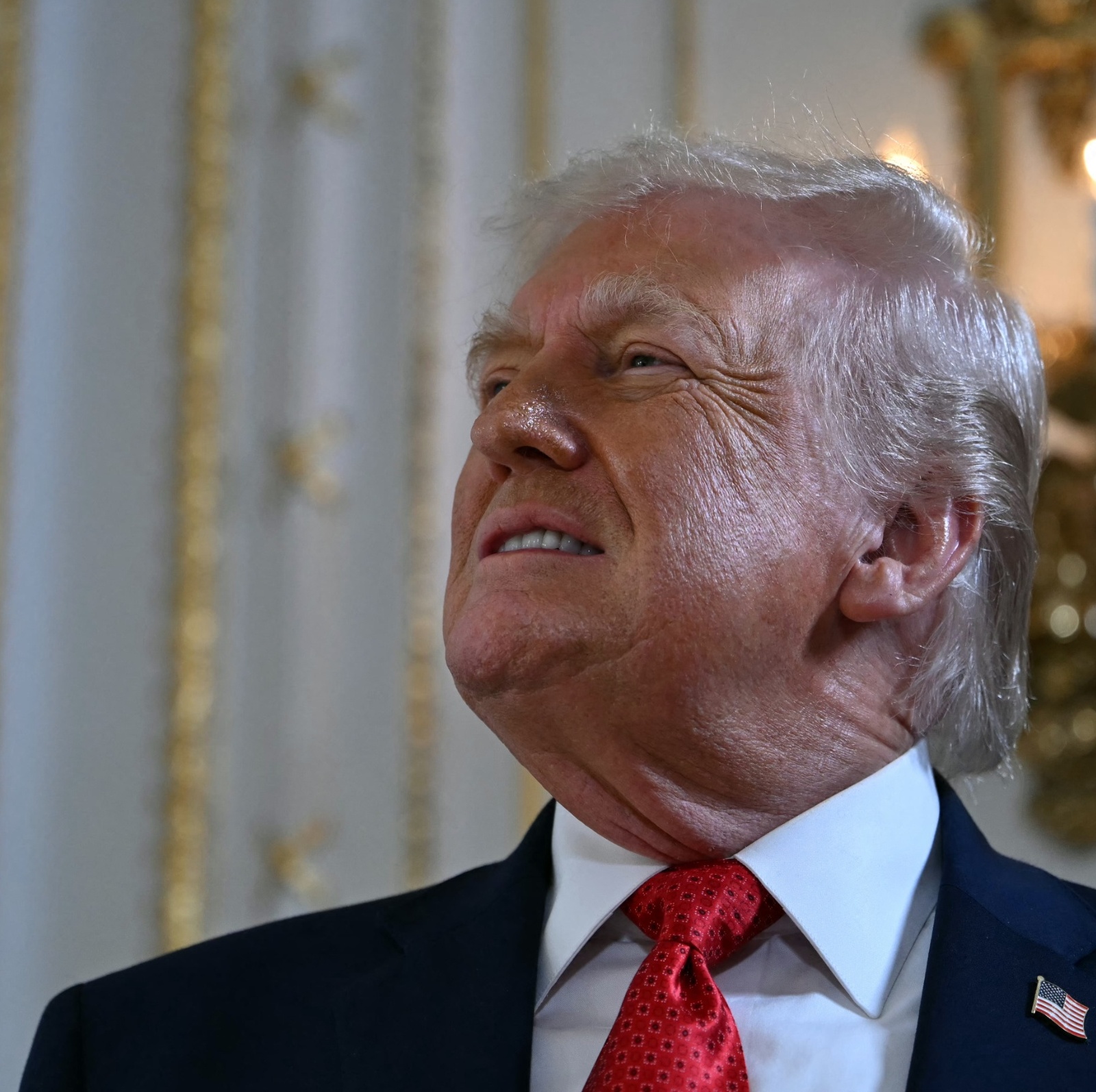 Trump smiles in the White House while looking at his golden ballroom