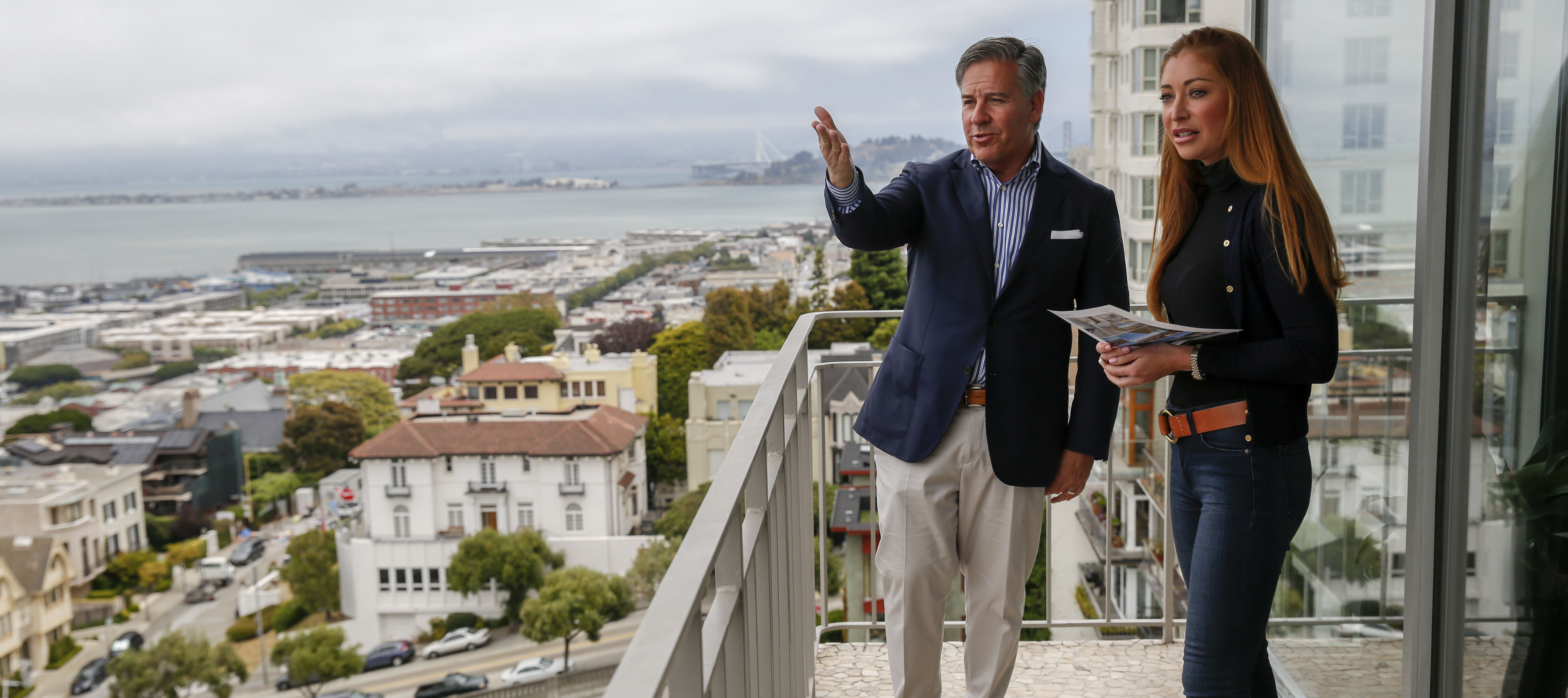 Young homebuyers, like a woman seen here on the balcony of condo in Russian Hill, can have an advantage as jobs in AI can come with hefty signing bonuses.