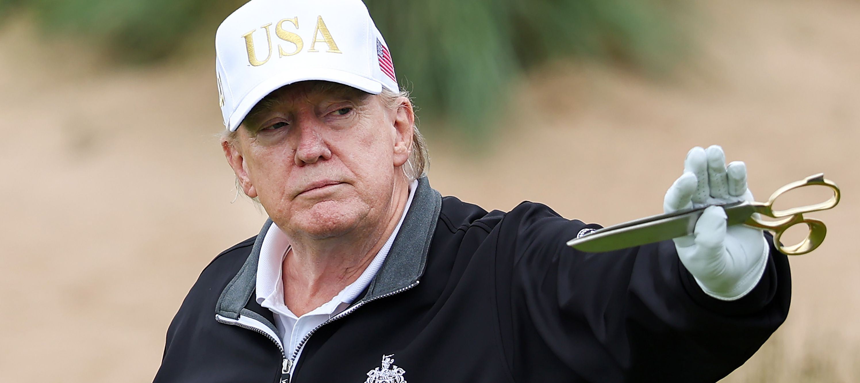 Donald Trump holds up a pair of scissor after cutting the ribbon for his his new golf course at his Trump International Golf links resort in Balmedie, Scotland.