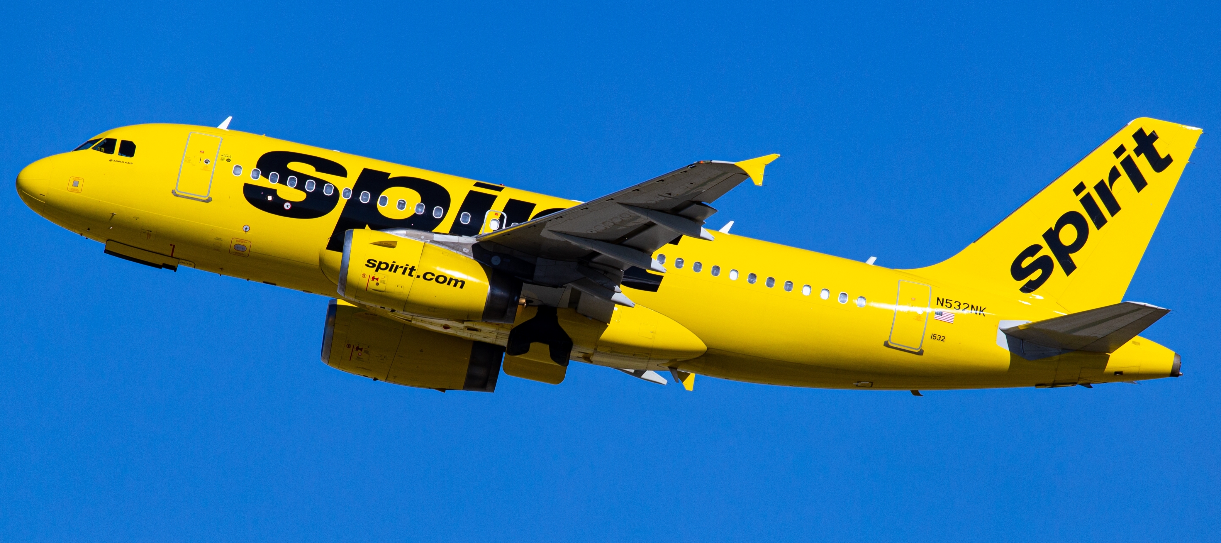 A Spirit Airlines plane is seen flying in the sky.