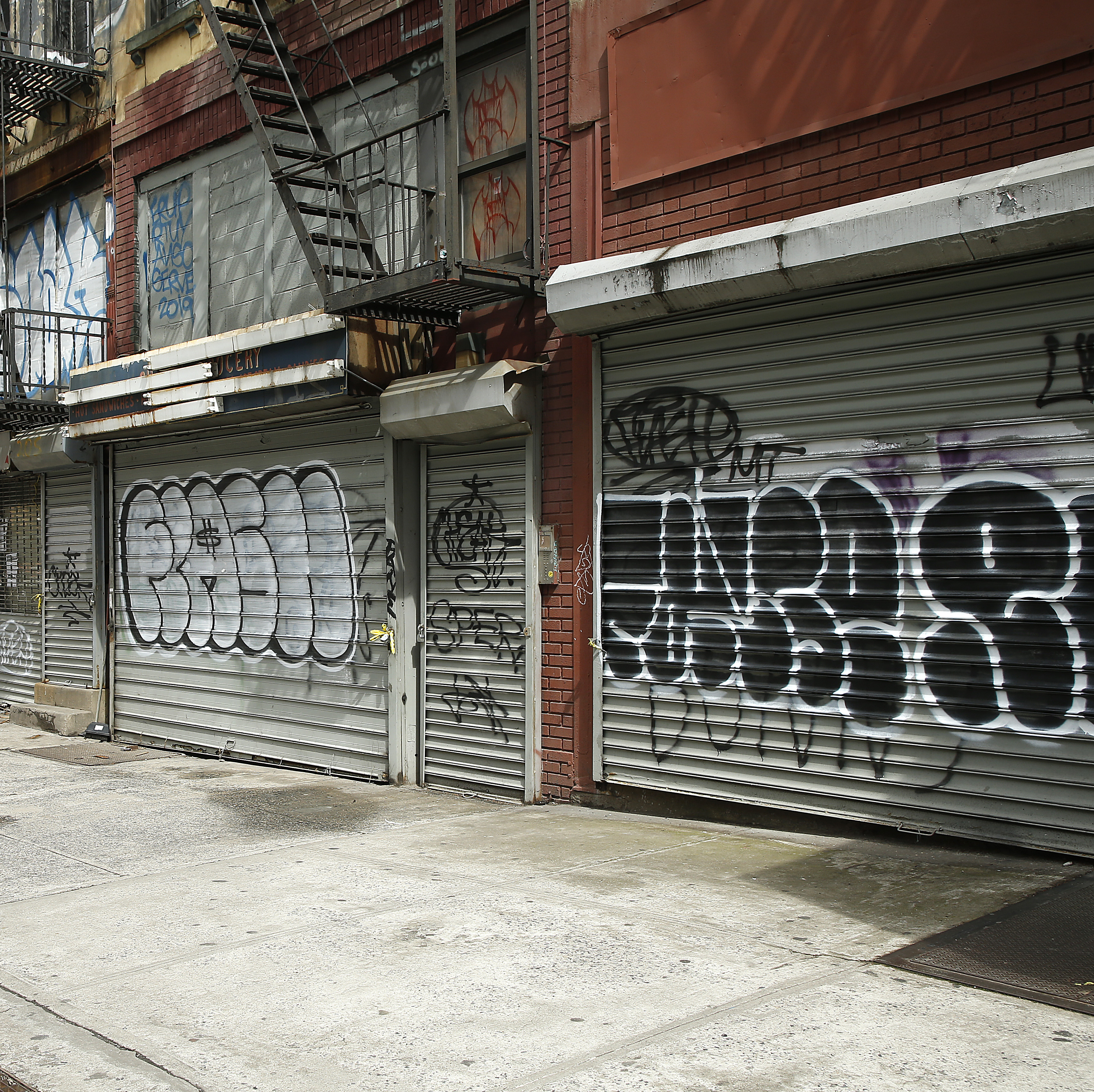 Small businesses in New York City with their security gates rolled down.