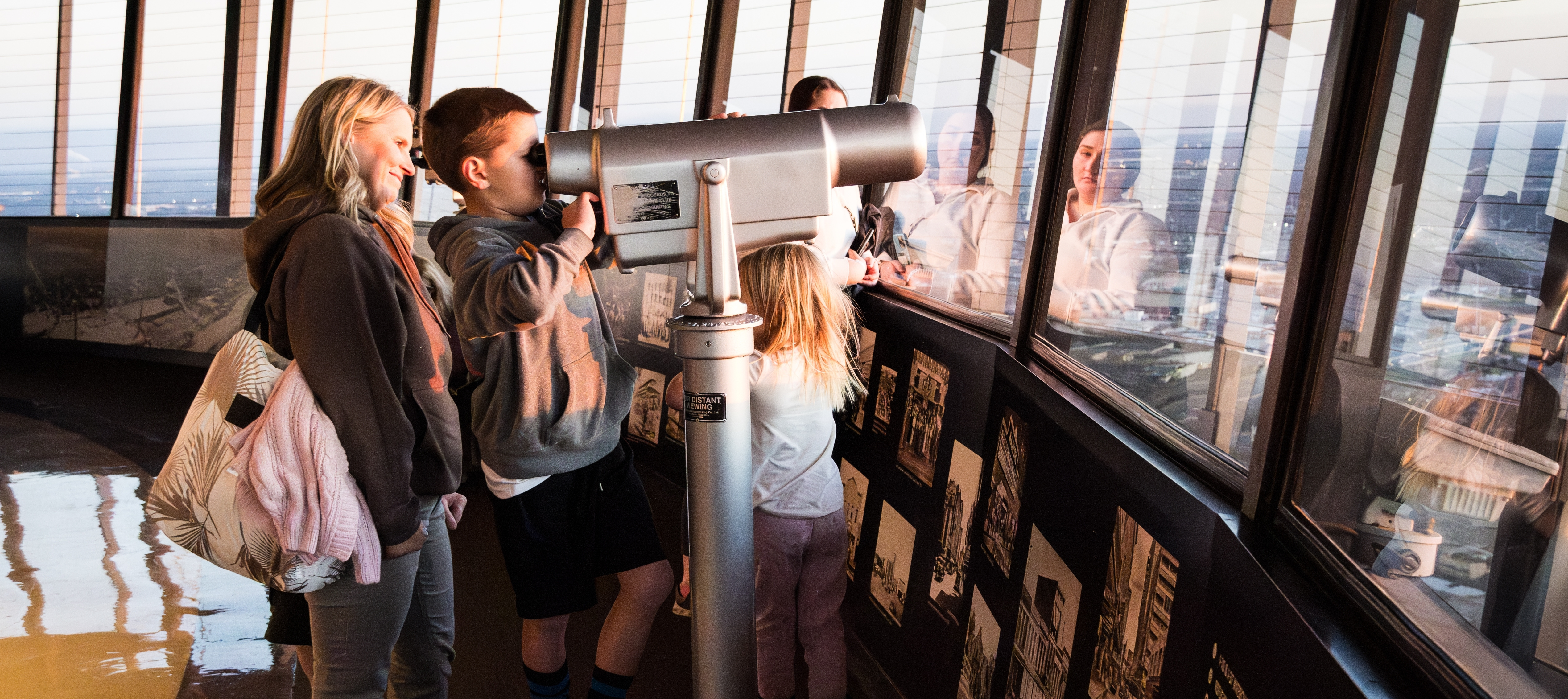 A mother and her children take in the sights from the observation deck of a local building.