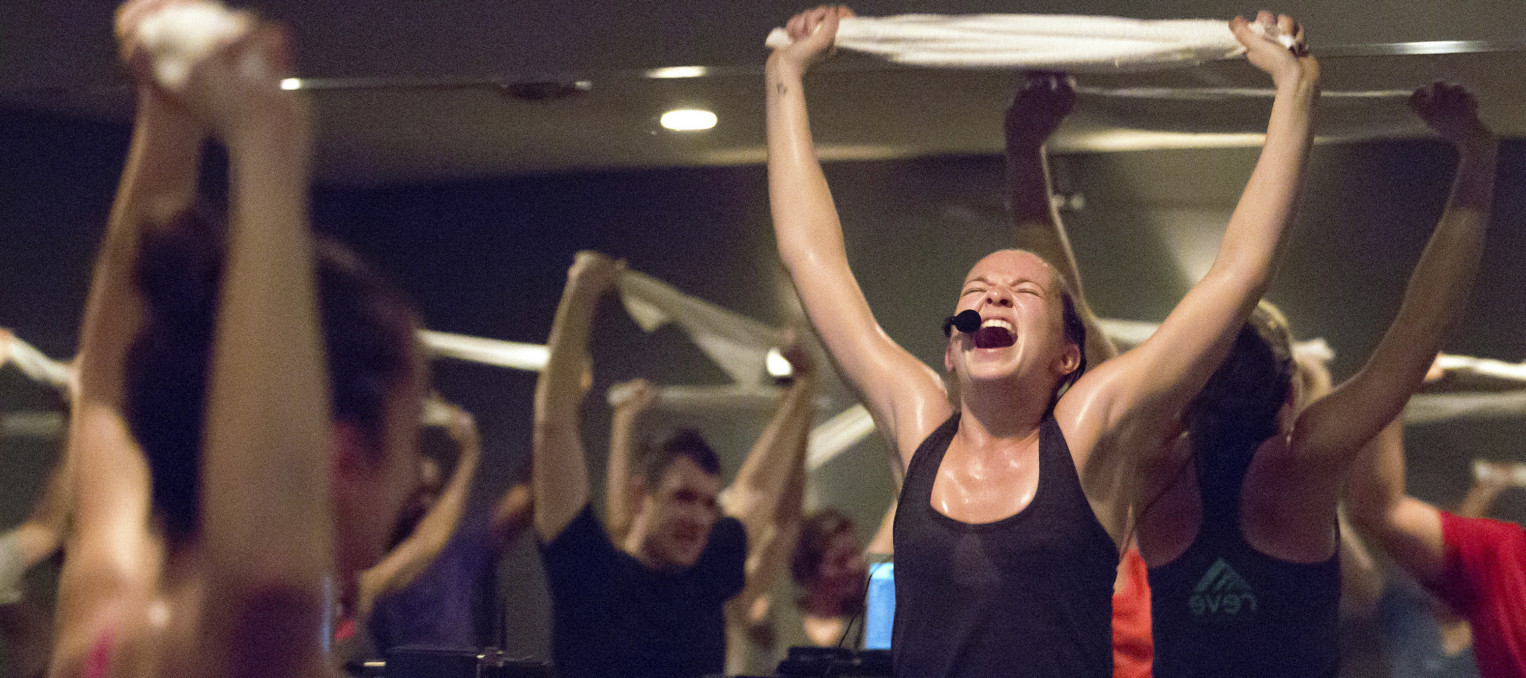 Spin classes, like the one seen here with an instructor holding a towel over her head as she leads a group during an early morning session, are now taking priority in the budget of Gen Zers.