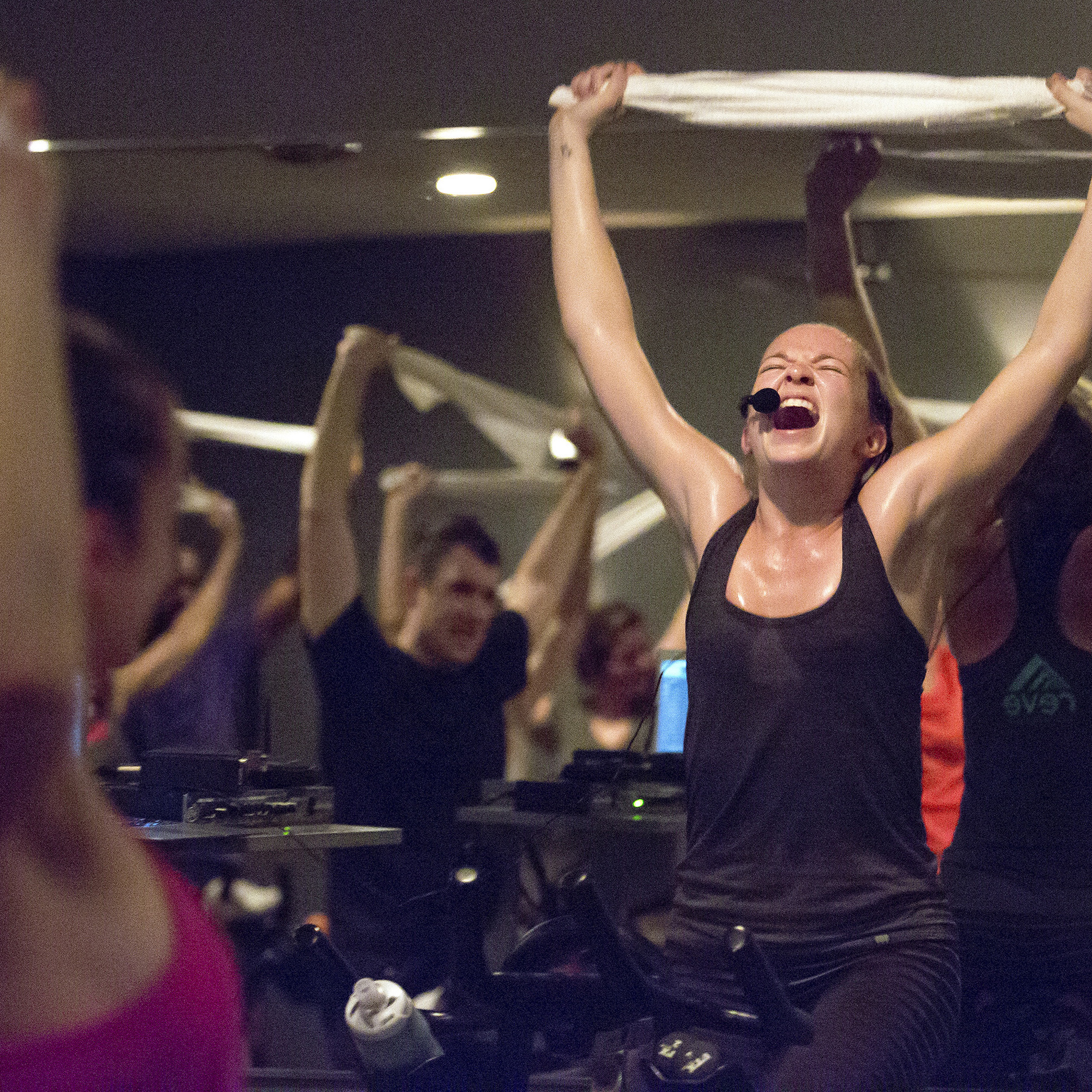Spin classes, like the one seen here with an instructor holding a towel over her head as she leads a group during an early morning session, are now taking priority in the budget of Gen Zers.