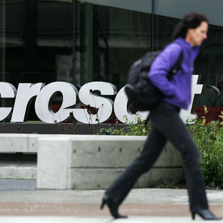 A photo of a woman walking past a Microsoft office