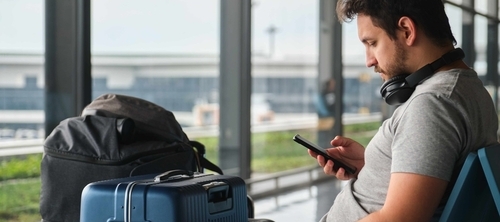 Man sitting at the airport with his luggage