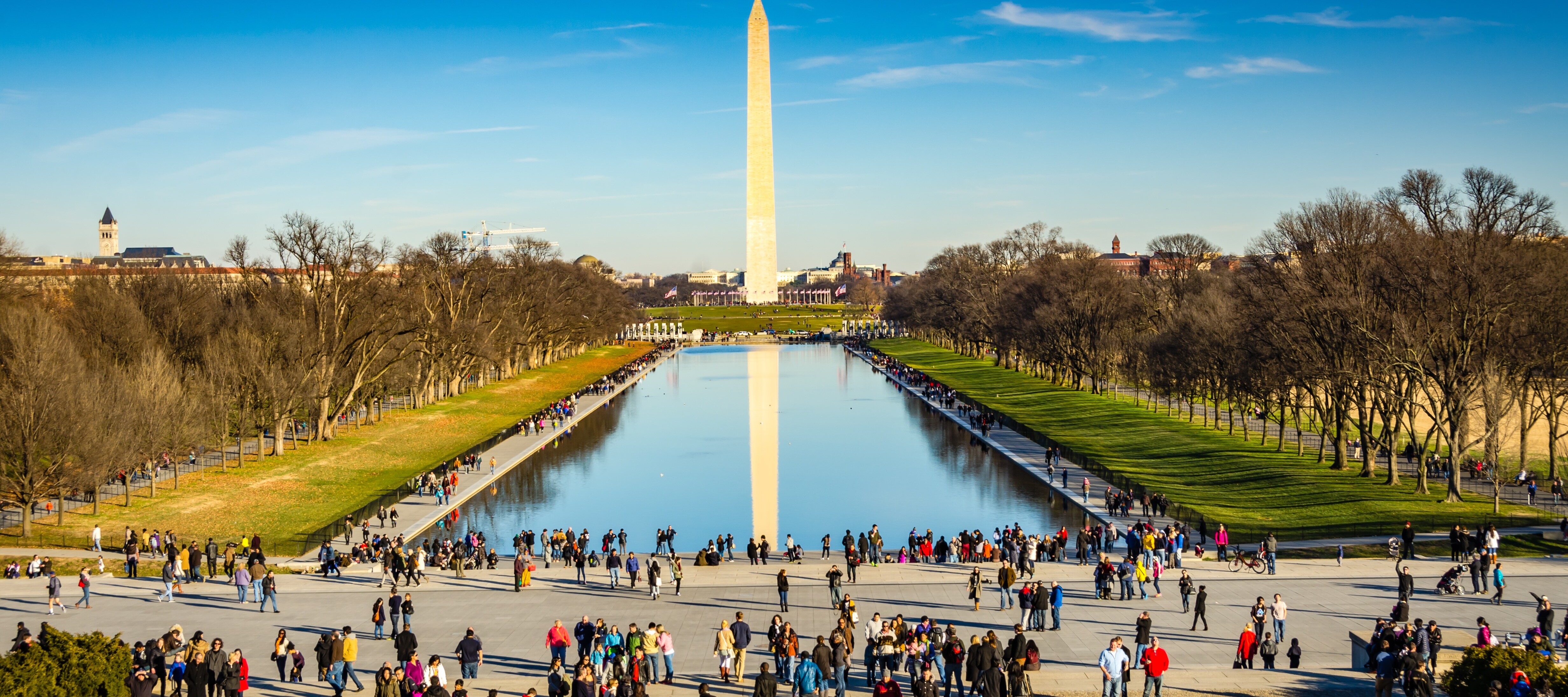 Washington Monument and The Reflecting Pool surrounded by tourists