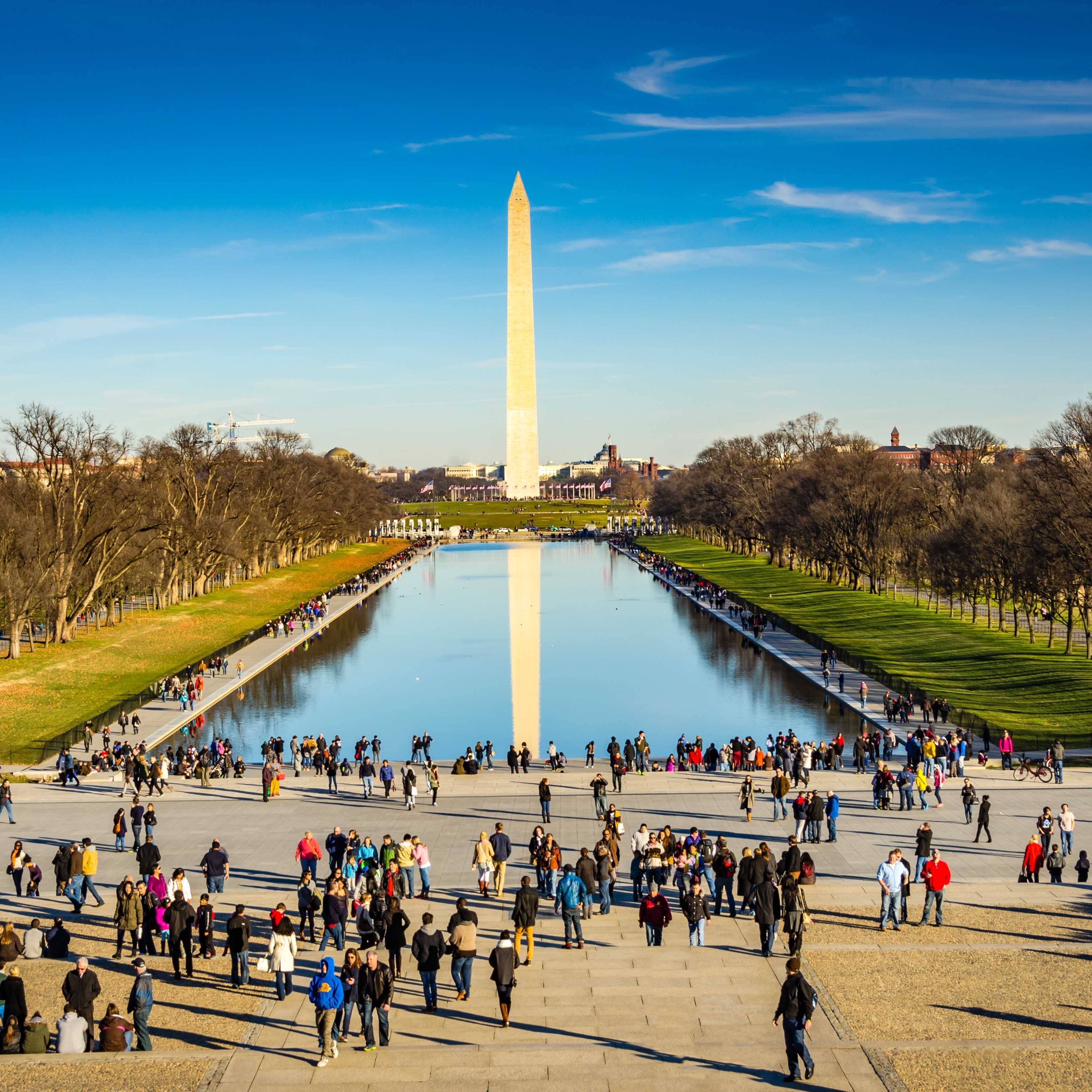 Washington Monument and The Reflecting Pool surrounded by tourists