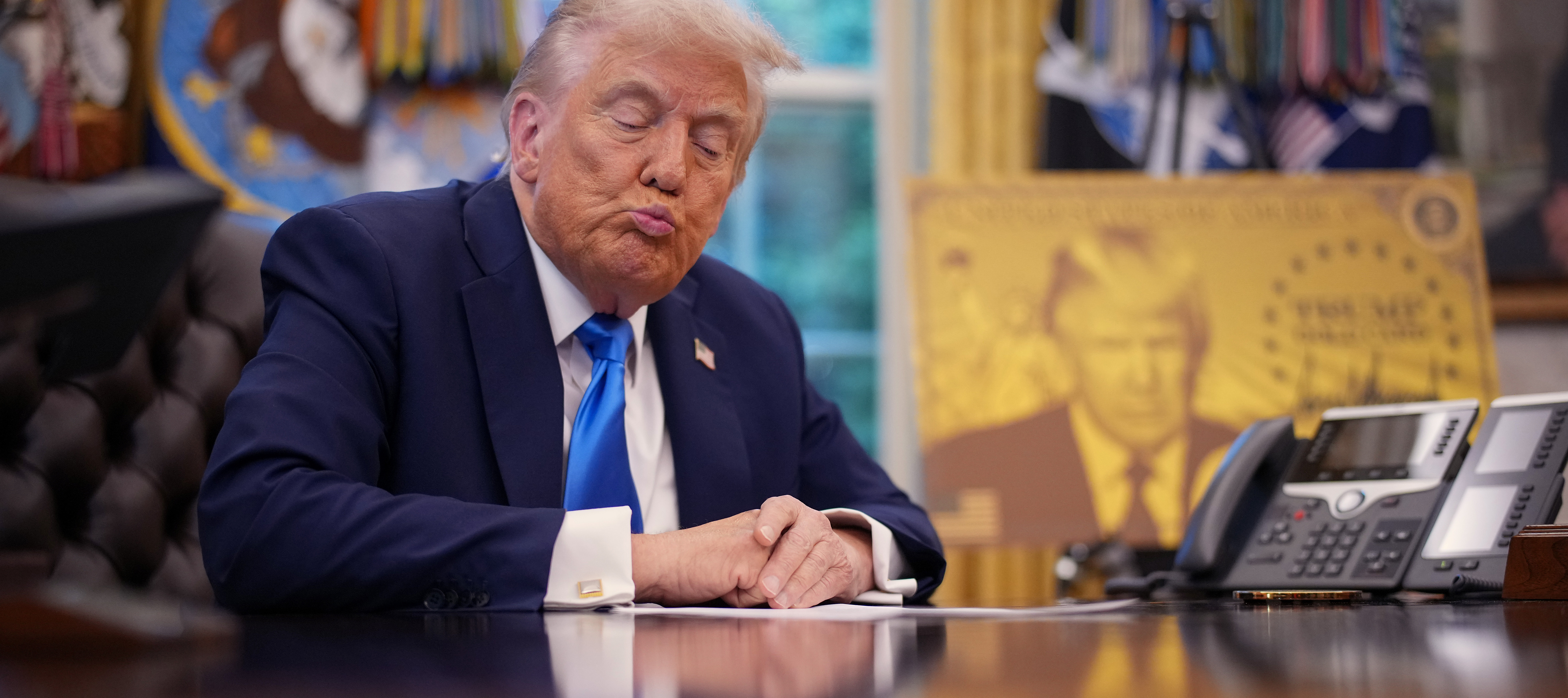 President Donald Trump purses his lips during a press conference promoting his Gold Card visa.