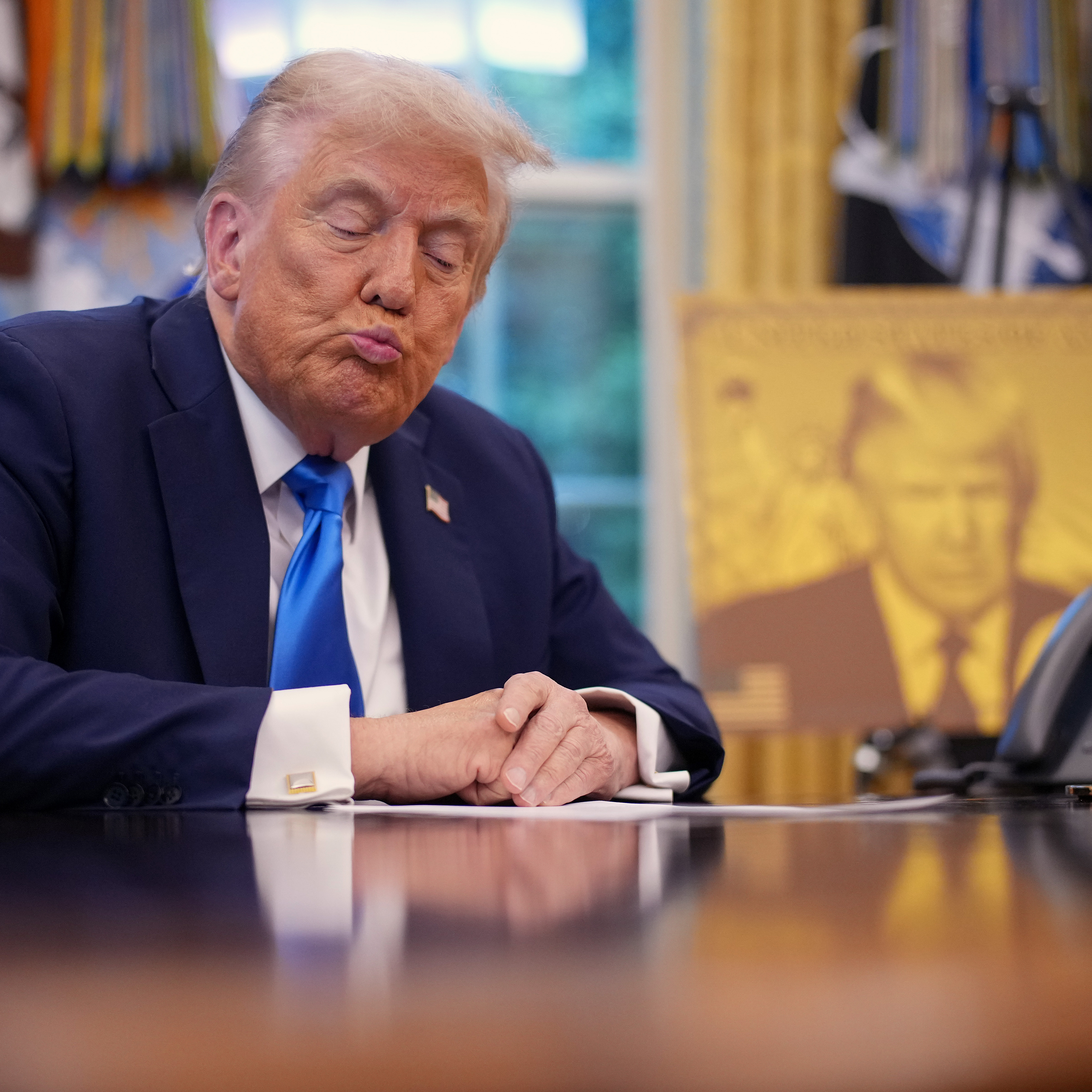 President Donald Trump purses his lips during a press conference promoting his Gold Card visa.