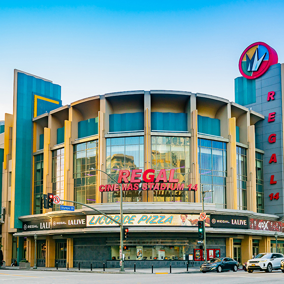 A central photo of Regal Cinema's flaghip theater in L.A. flanked Dune actors Zendaya and Timothy Chalamet.