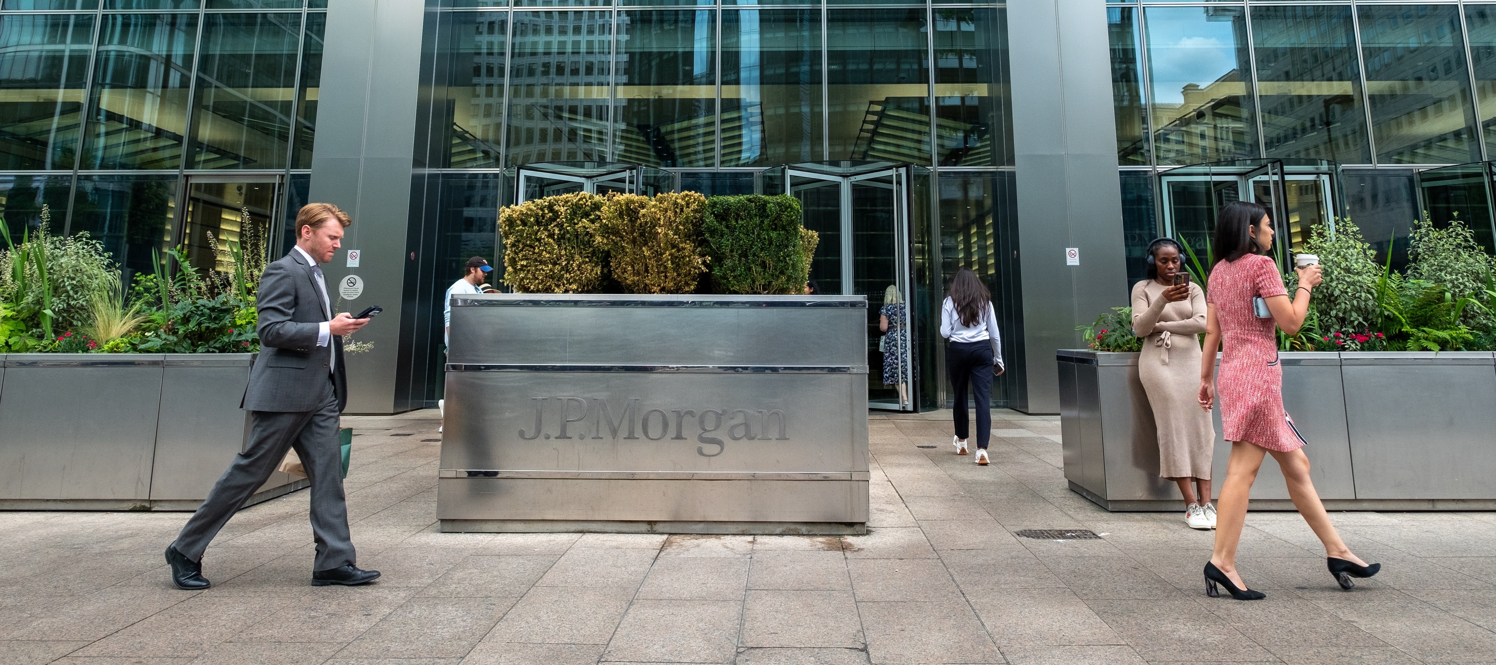 Image of a JPMorgan building with people walking in front of the signage.