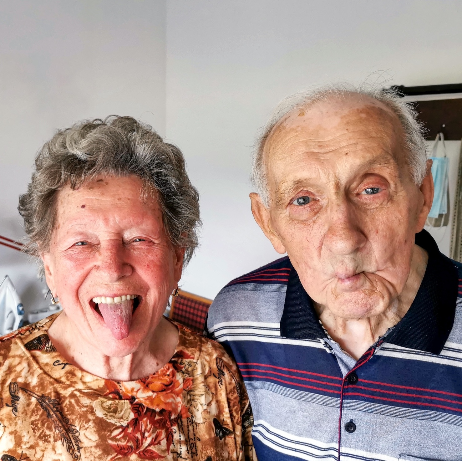 A photo of an elderly couple making silly faces