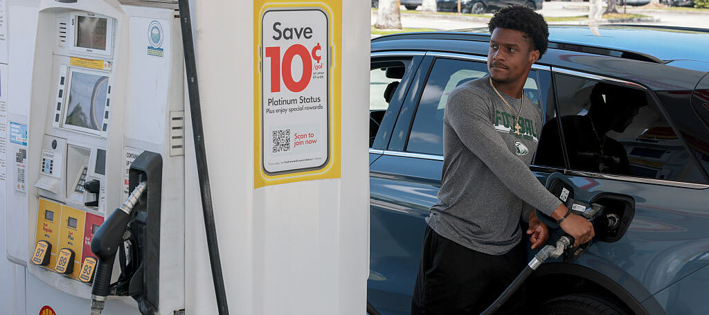 A customer fills up their car's gas tank at a gas station