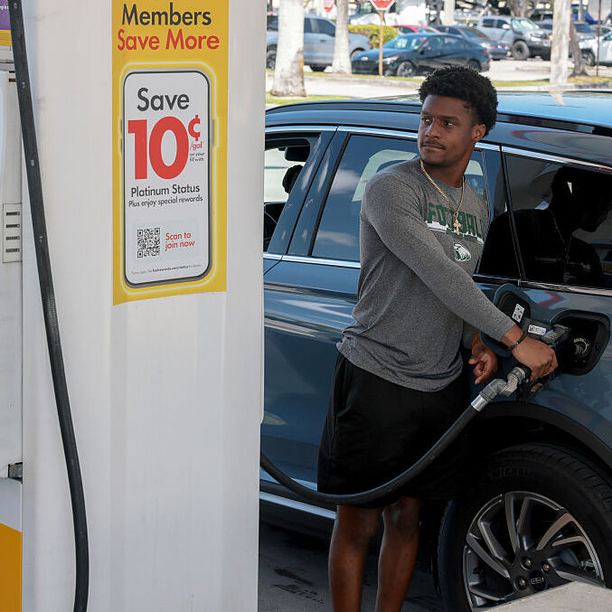 A customer fills up their car's gas tank at a gas station