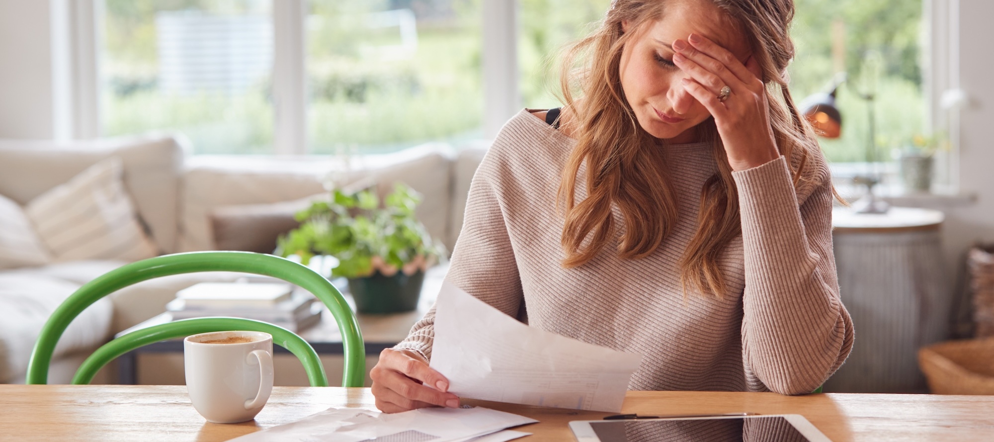 A woman stressed out reviewing bills at a table