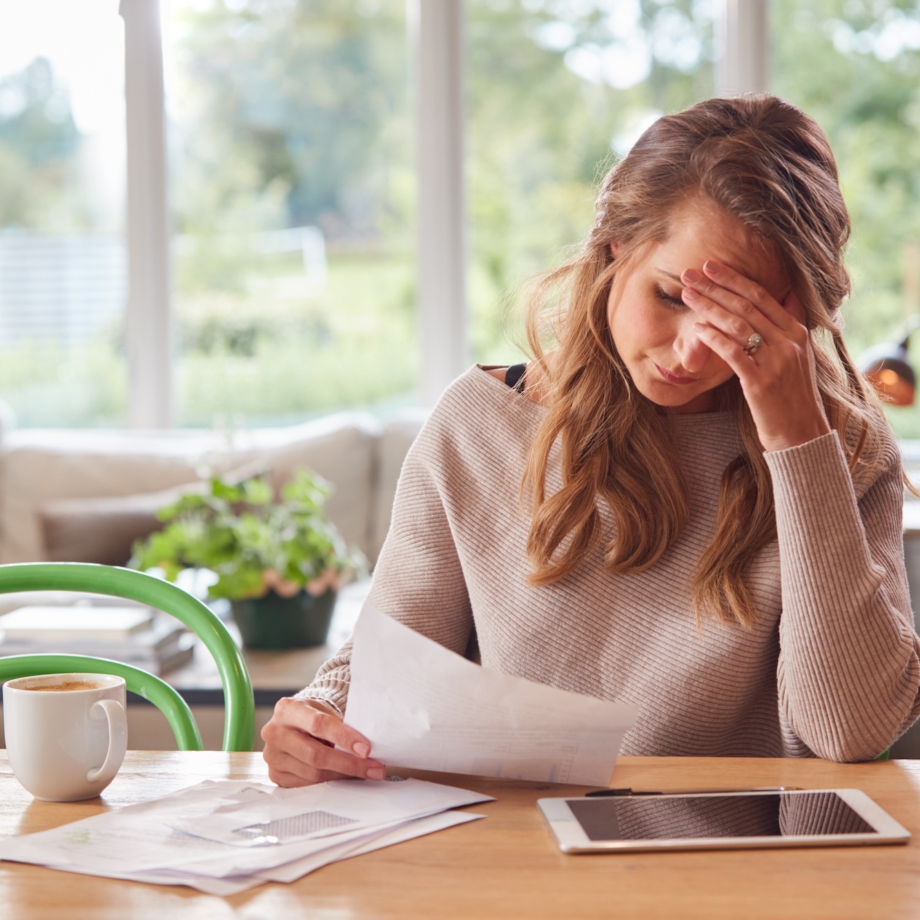 A woman stressed out reviewing bills at a table