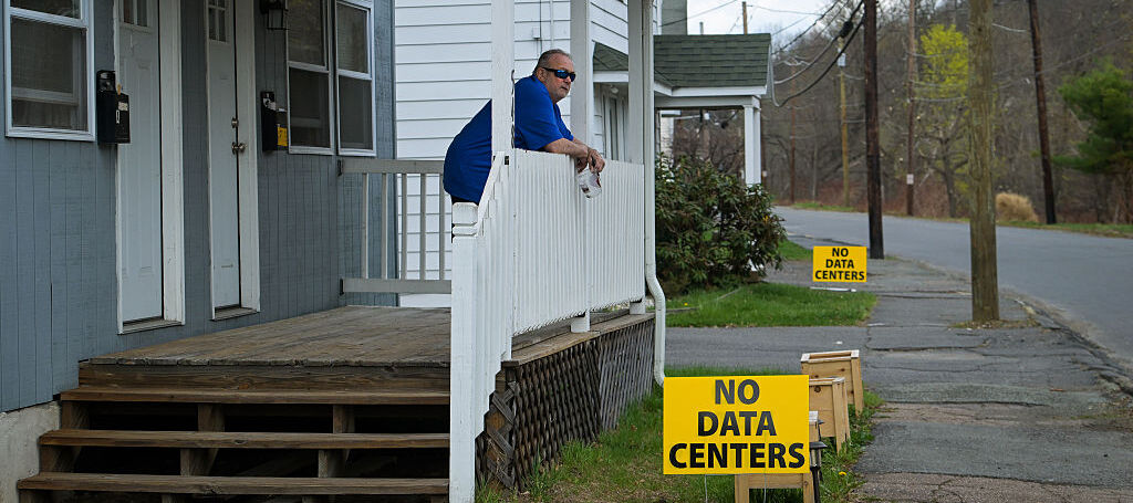 A resident is pictured on his porch in Archbald, PA with a sign that read, "No data centers"