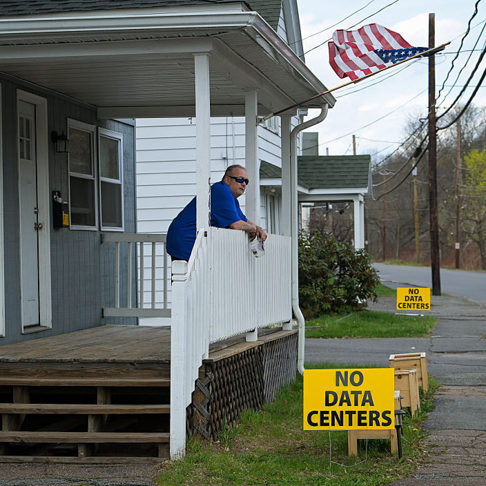 A resident is pictured on his porch in Archbald, PA with a sign that read, "No data centers"