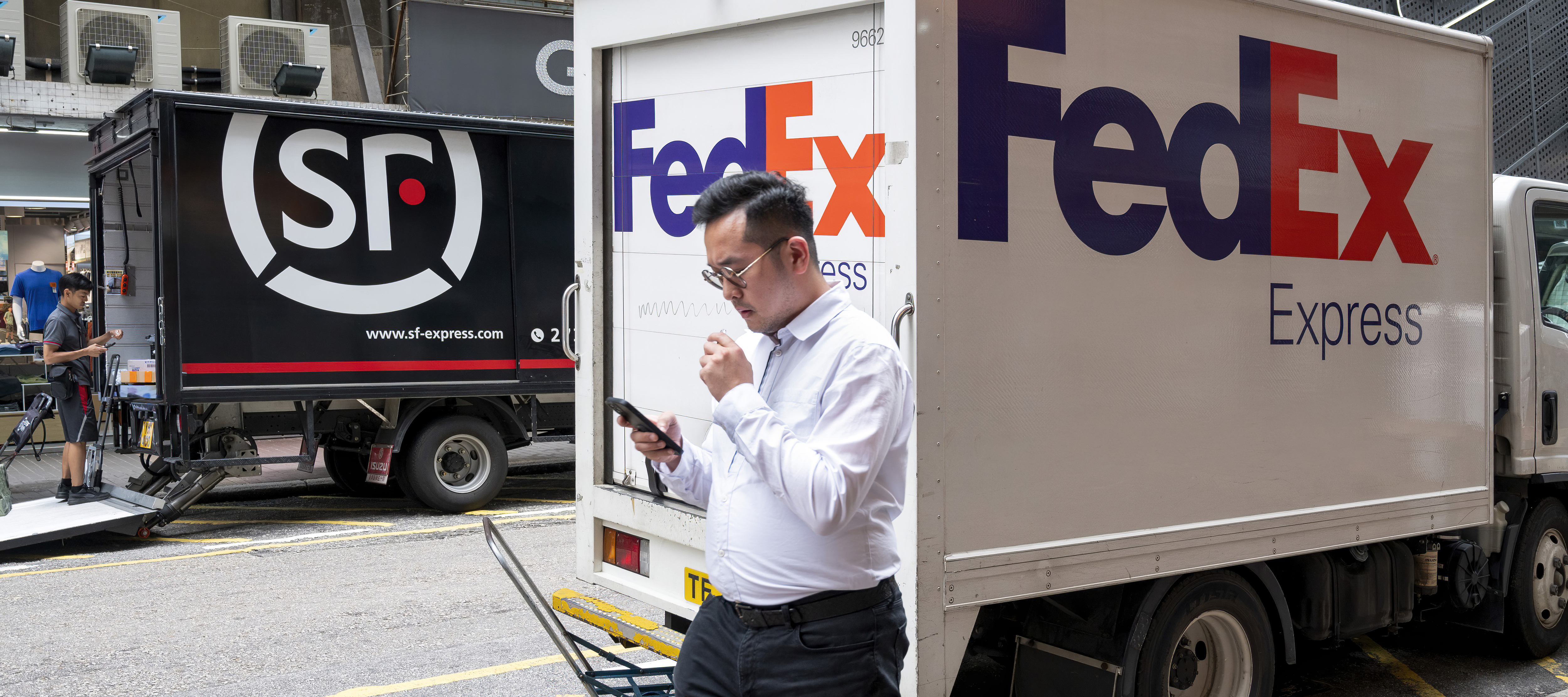 Aman walks by a FedEx truck.