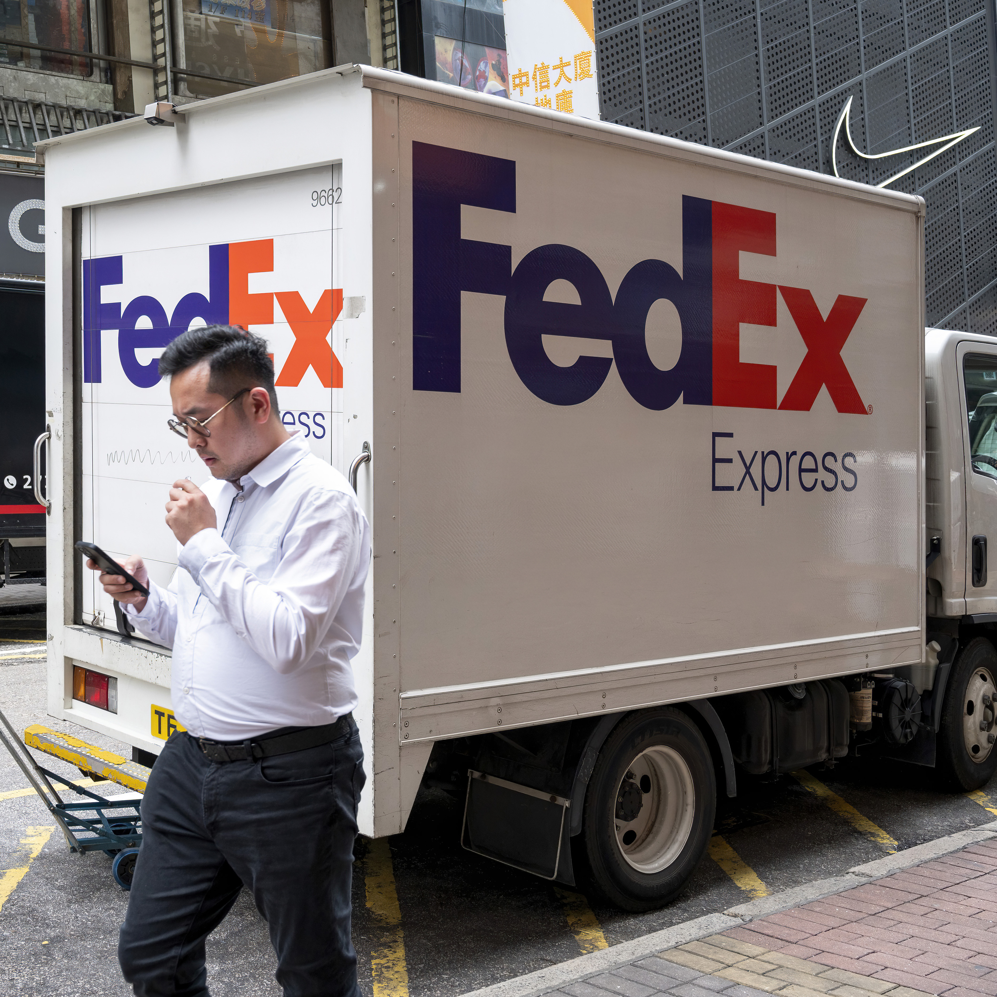 Aman walks by a FedEx truck.