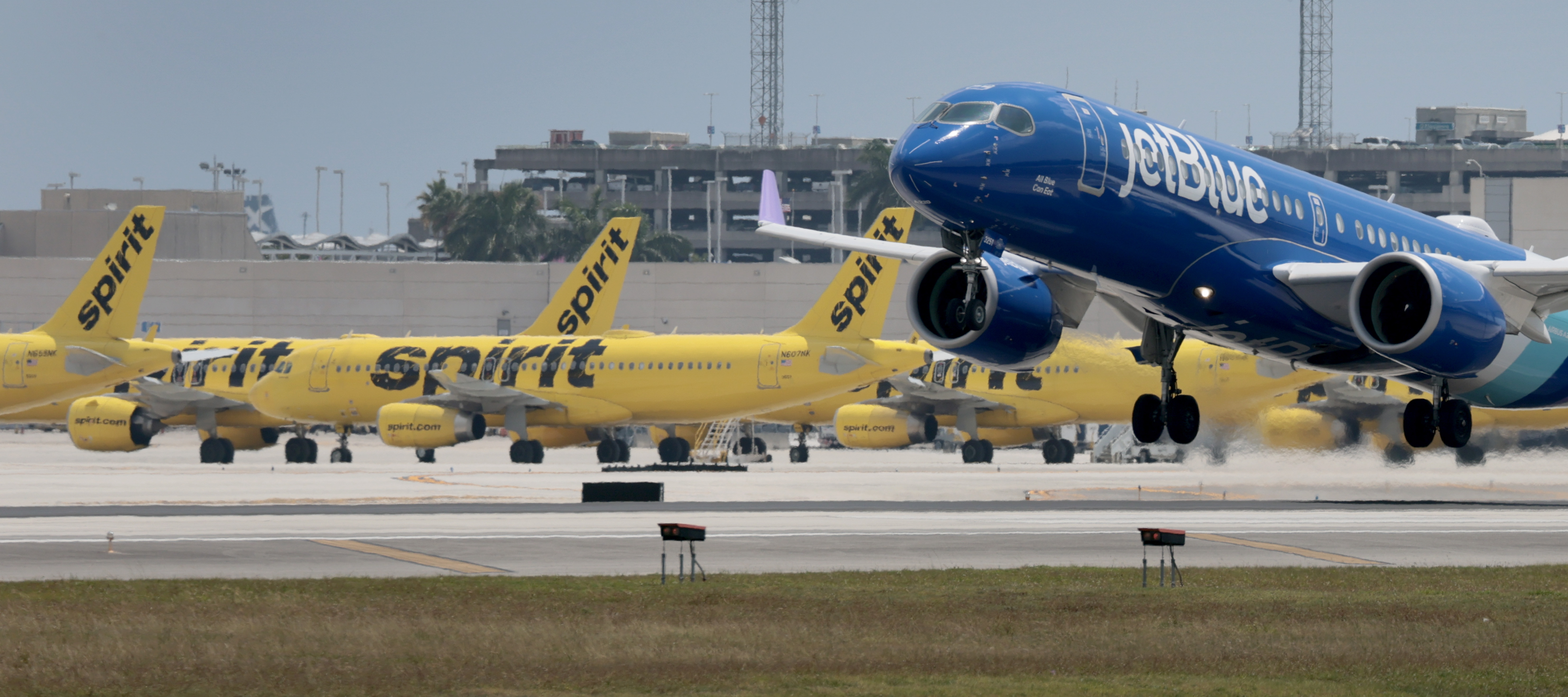 A  JetBlue plane takes off near idle Spirit Airlines planes on the tarmac at the Fort Lauderdale-Hollywood International Airport on May 02, 2026 in Fort Lauderdale, Florida.