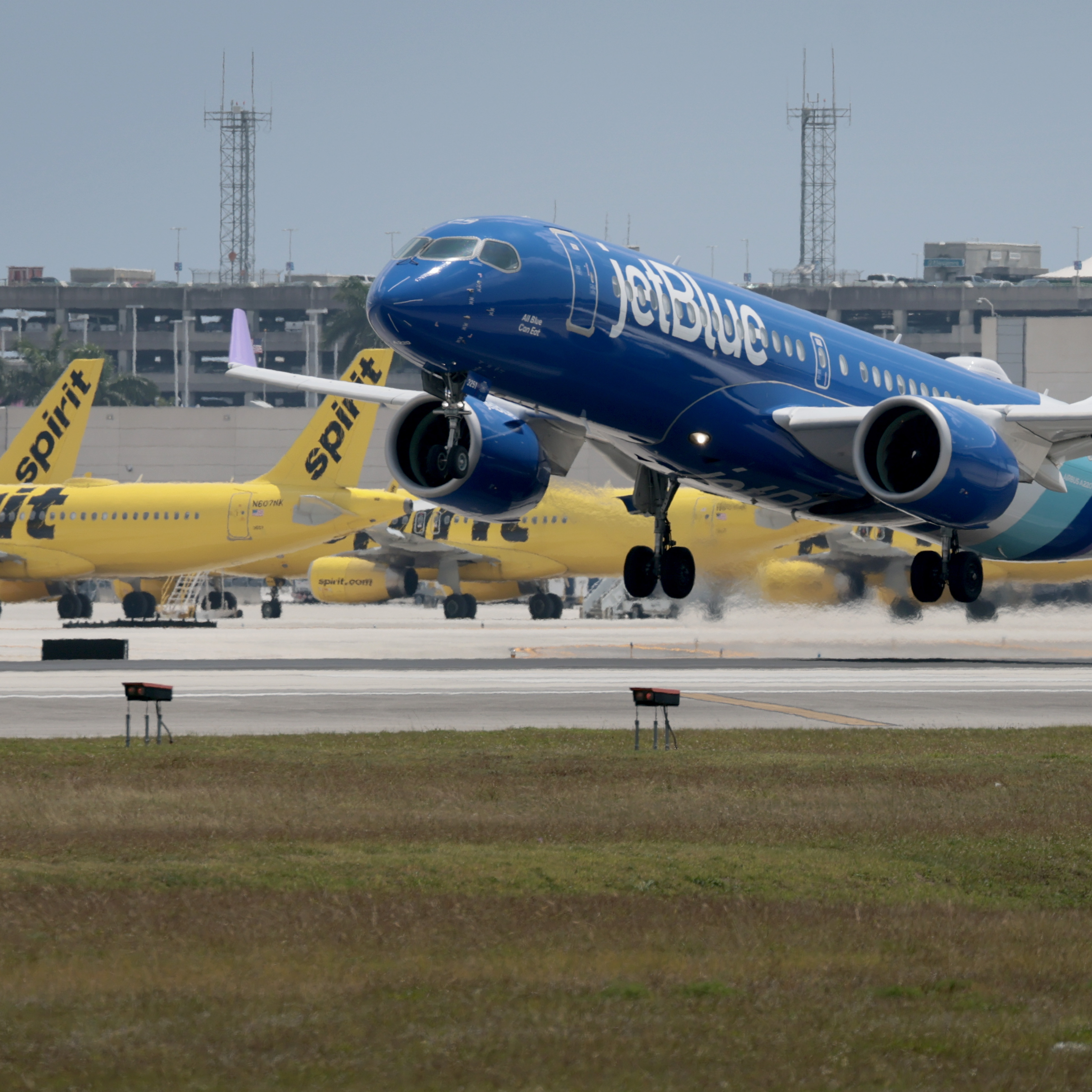 A  JetBlue plane takes off near idle Spirit Airlines planes on the tarmac at the Fort Lauderdale-Hollywood International Airport on May 02, 2026 in Fort Lauderdale, Florida.