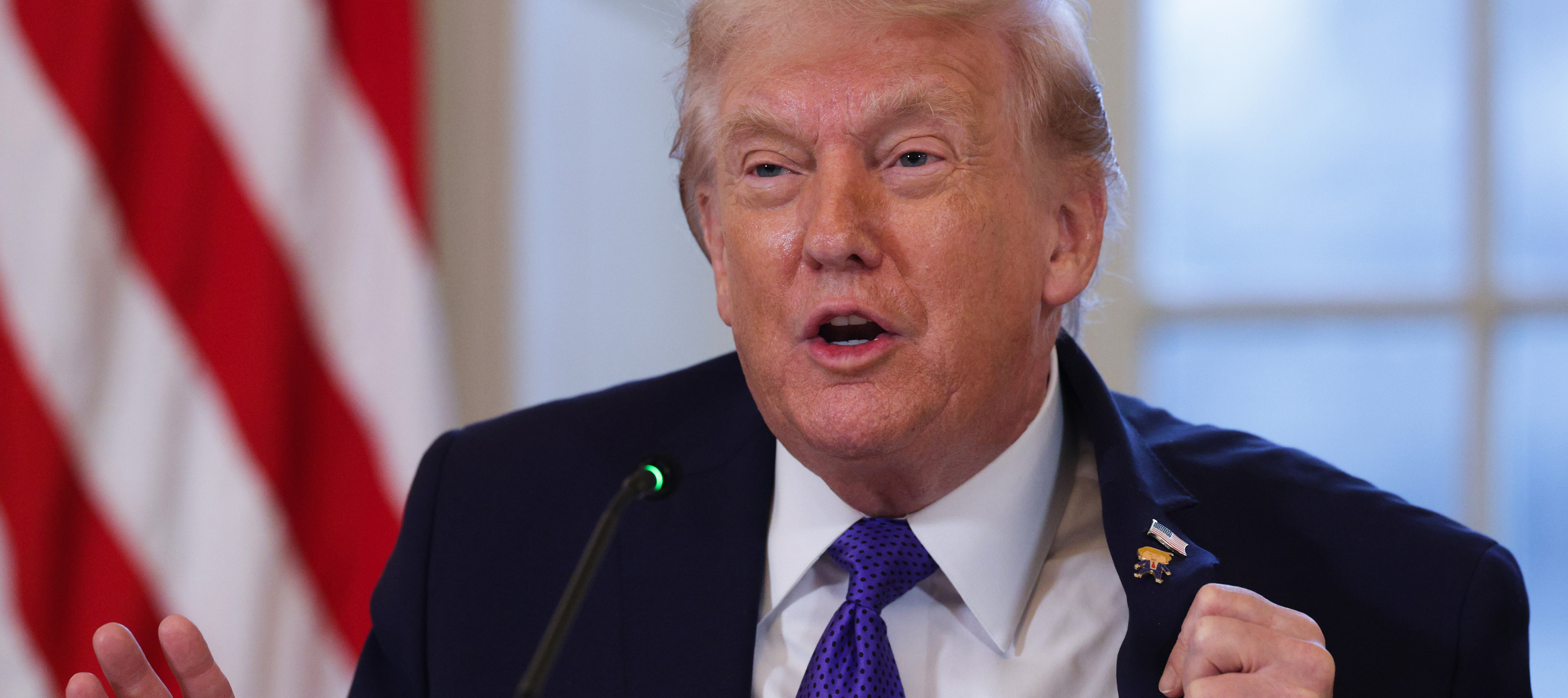 Trump holding a meeting in the East Room of the White House.
