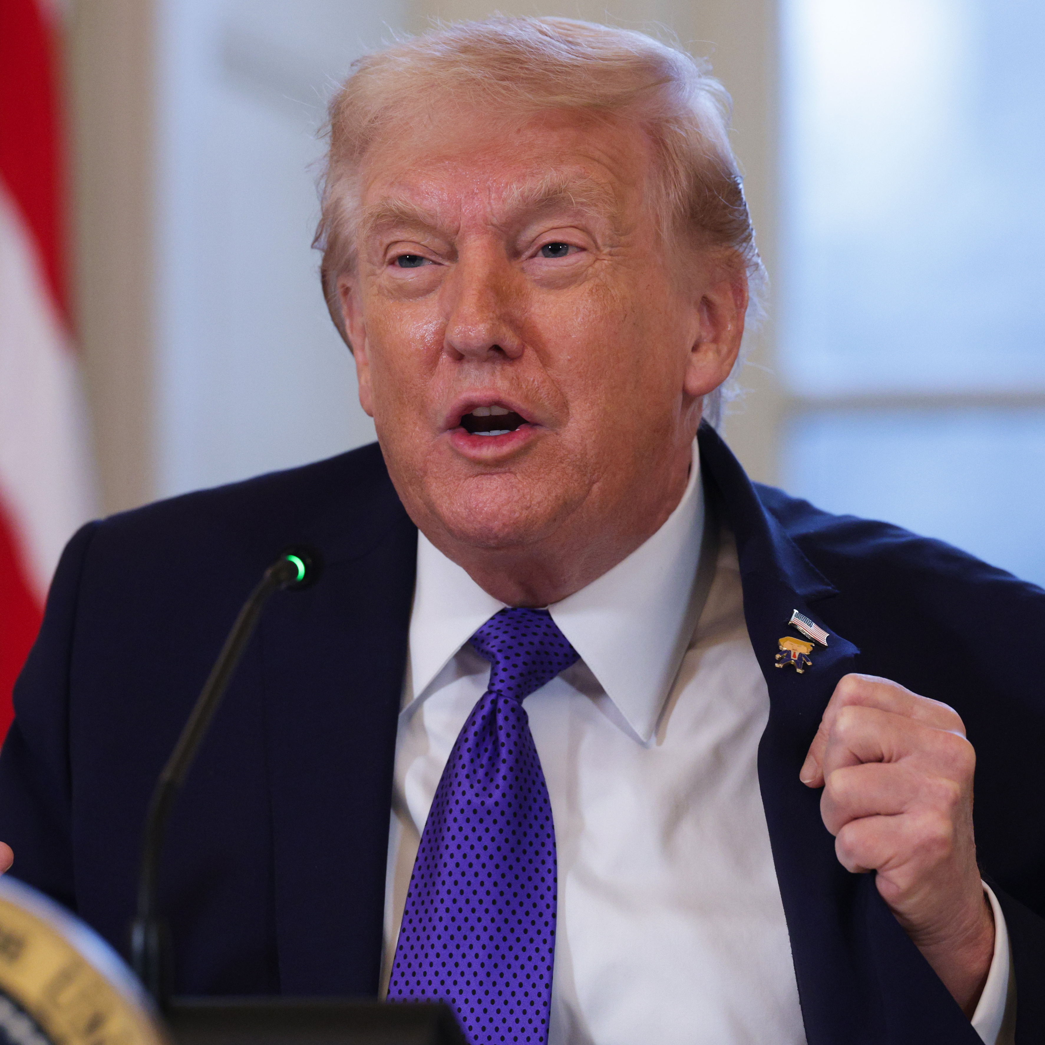 Trump holding a meeting in the East Room of the White House.